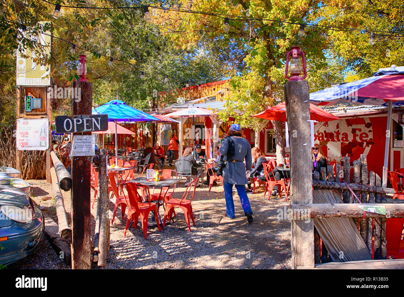 Le persone che si godono i colori dell'autunno e temps mentre si mangia fuori all'Hollar ristorante di Madrid, New Mexico Foto Stock