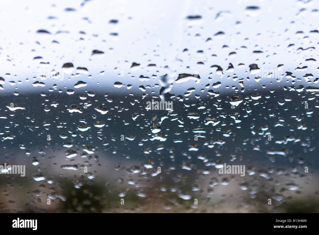 Gocce di acqua dopo la pioggia sulla finestra sporca. Foto Stock