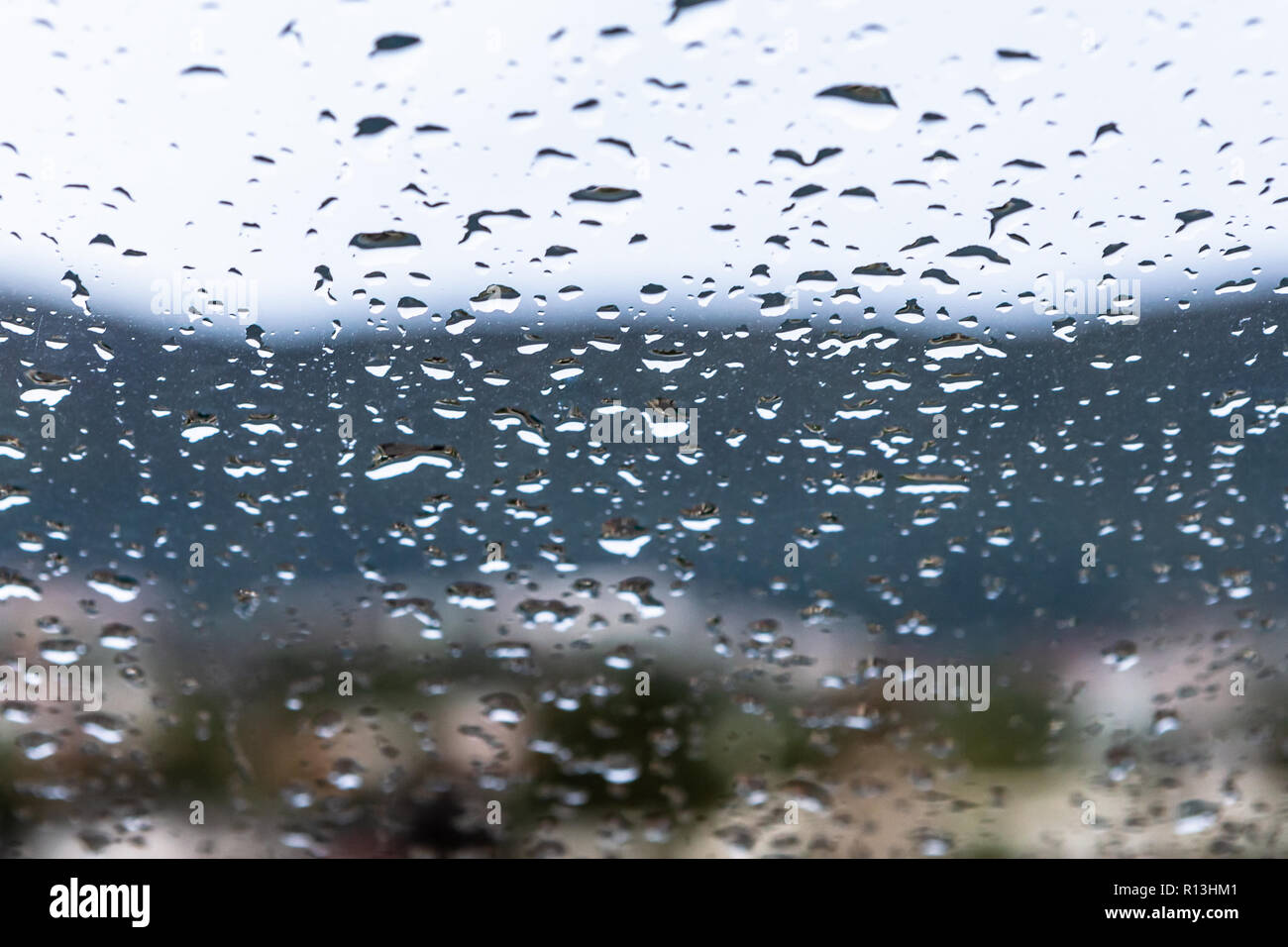 Gocce di acqua dopo la pioggia sulla finestra sporca. Foto Stock