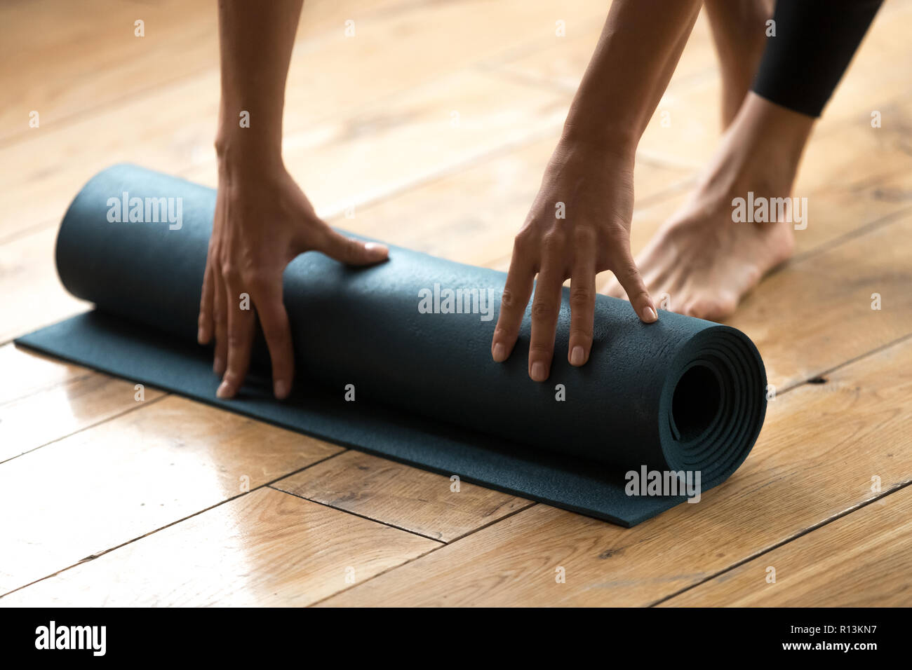Donna inizio della sua pratica e lo svolgimento di blu esercizio fitness Foto Stock