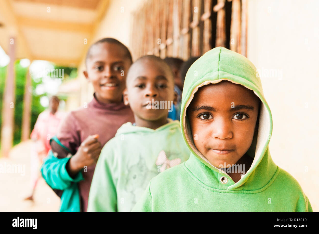 Bafoussam, Camerun - 06 agosto 2018: close up ritratto di giovane africano scuola per bambini cercando nella fotocamera con sorriso e gioia con grandi occhi Foto Stock