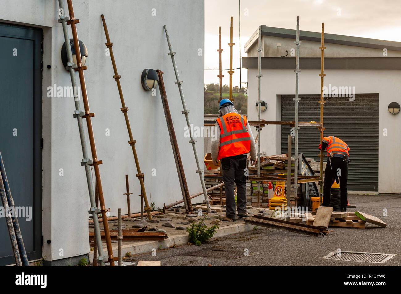 Lavoratori di impalcatura erigere impalcature sul lato di un edificio in West Cork, Irlanda. Foto Stock