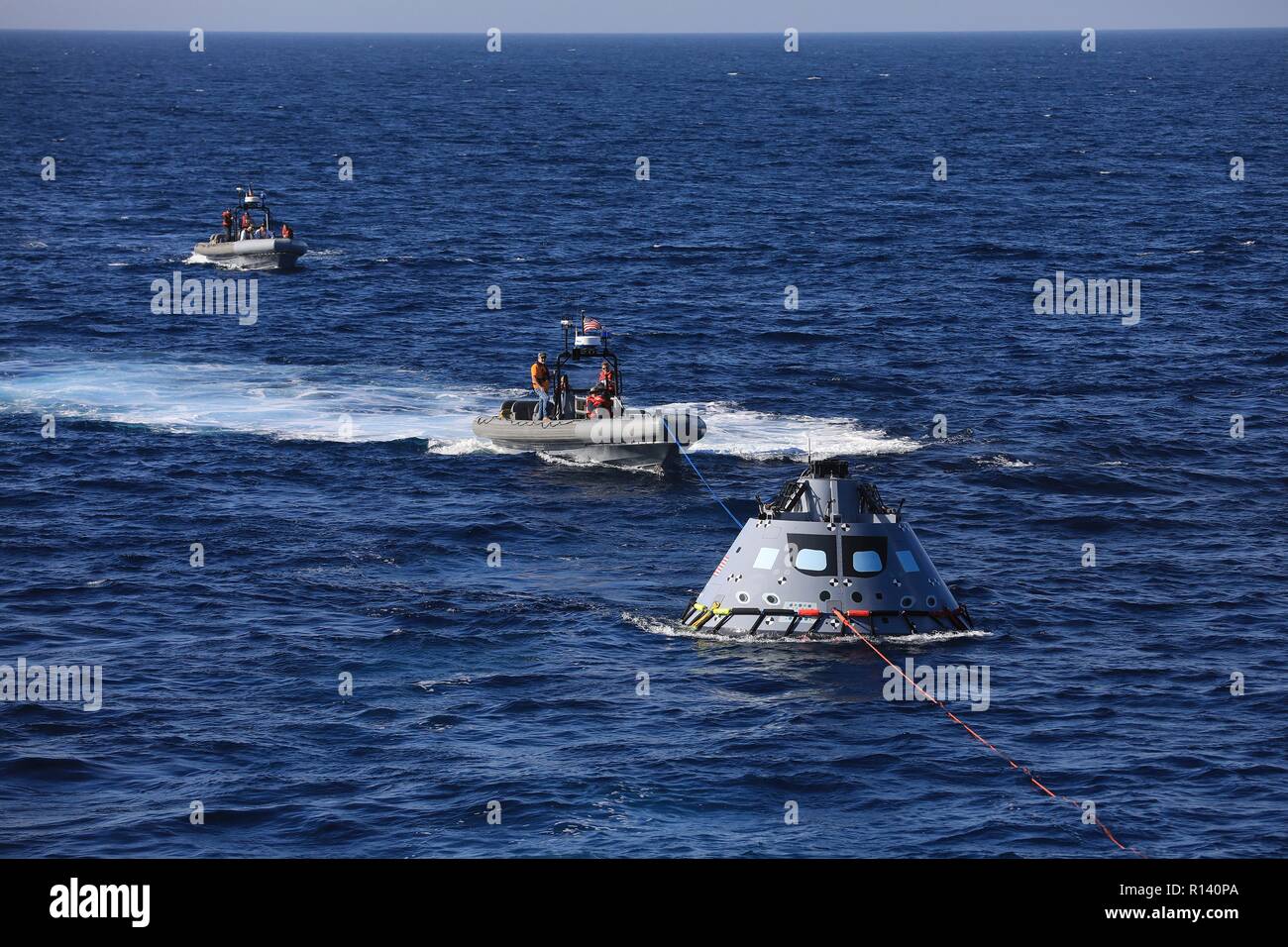 La NASA squadra di recupero e U.S. Navy divers trainare un mock up versione di Orion next generation space capsule per la USS John P. Murtha durante un oceano aperto prova di recupero 31 ottobre 2018 nell'Oceano Pacifico. La NASA e gli Stati Uniti La marina non ha eseguito oceano aperto il recupero di un manned space capsule poiché il progetto Apollo negli anni sessanta e sono le procedure di test e la bulloneria che verranno utilizzate per recuperare il veicolo spaziale Orion dopo che schizza verso il basso nell'Oceano Pacifico seguendo il futuro dello spazio profondo missioni di esplorazione. Foto Stock