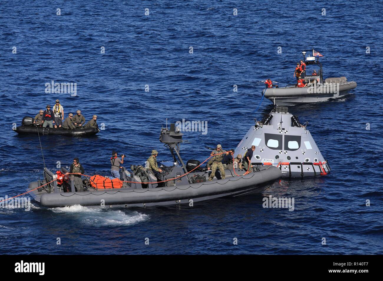 La NASA squadra di recupero e U.S. Navy divers fissare un mock up versione di Orion la generazione successiva capsula spaziale che si preparano a portarlo nella ben coperta della USS John P. Murtha durante un oceano aperto prova di recupero 31 ottobre 2018 nell'Oceano Pacifico. La NASA e gli Stati Uniti La marina non ha eseguito oceano aperto il recupero di un manned space capsule poiché il progetto Apollo negli anni sessanta e sono le procedure di test e la bulloneria che verranno utilizzate per recuperare il veicolo spaziale Orion dopo che schizza verso il basso nell'Oceano Pacifico seguendo il futuro dello spazio profondo missioni di esplorazione. Foto Stock