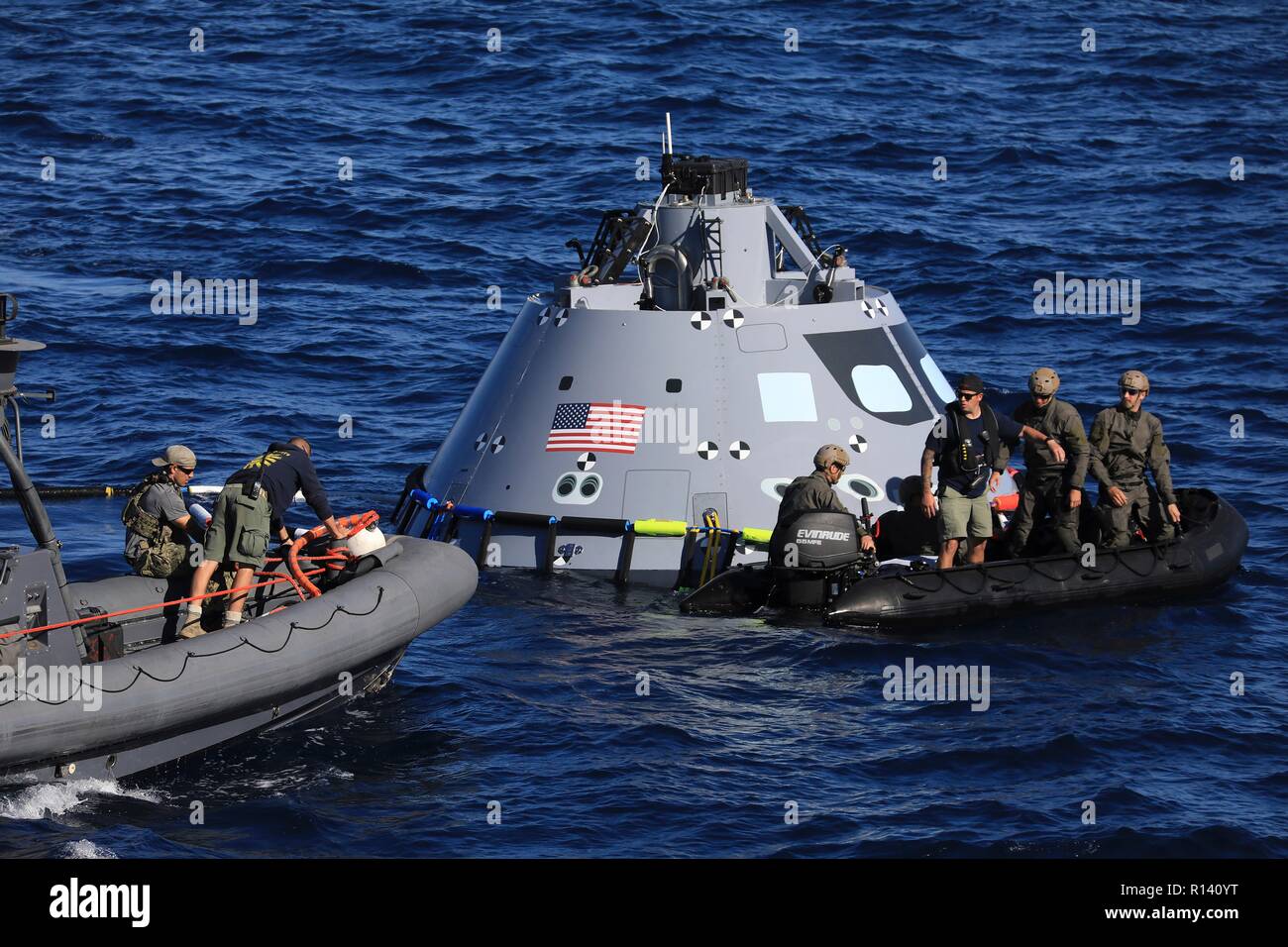 La NASA squadra di recupero e U.S. Navy divers fissare un mock up versione di Orion la generazione successiva capsula spaziale che si preparano a portarlo nella ben coperta della USS John P. Murtha durante un oceano aperto prova di recupero 31 ottobre 2018 nell'Oceano Pacifico. La NASA e gli Stati Uniti La marina non ha eseguito oceano aperto il recupero di un manned space capsule poiché il progetto Apollo negli anni sessanta e sono le procedure di test e la bulloneria che verranno utilizzate per recuperare il veicolo spaziale Orion dopo che schizza verso il basso nell'Oceano Pacifico seguendo il futuro dello spazio profondo missioni di esplorazione. Foto Stock