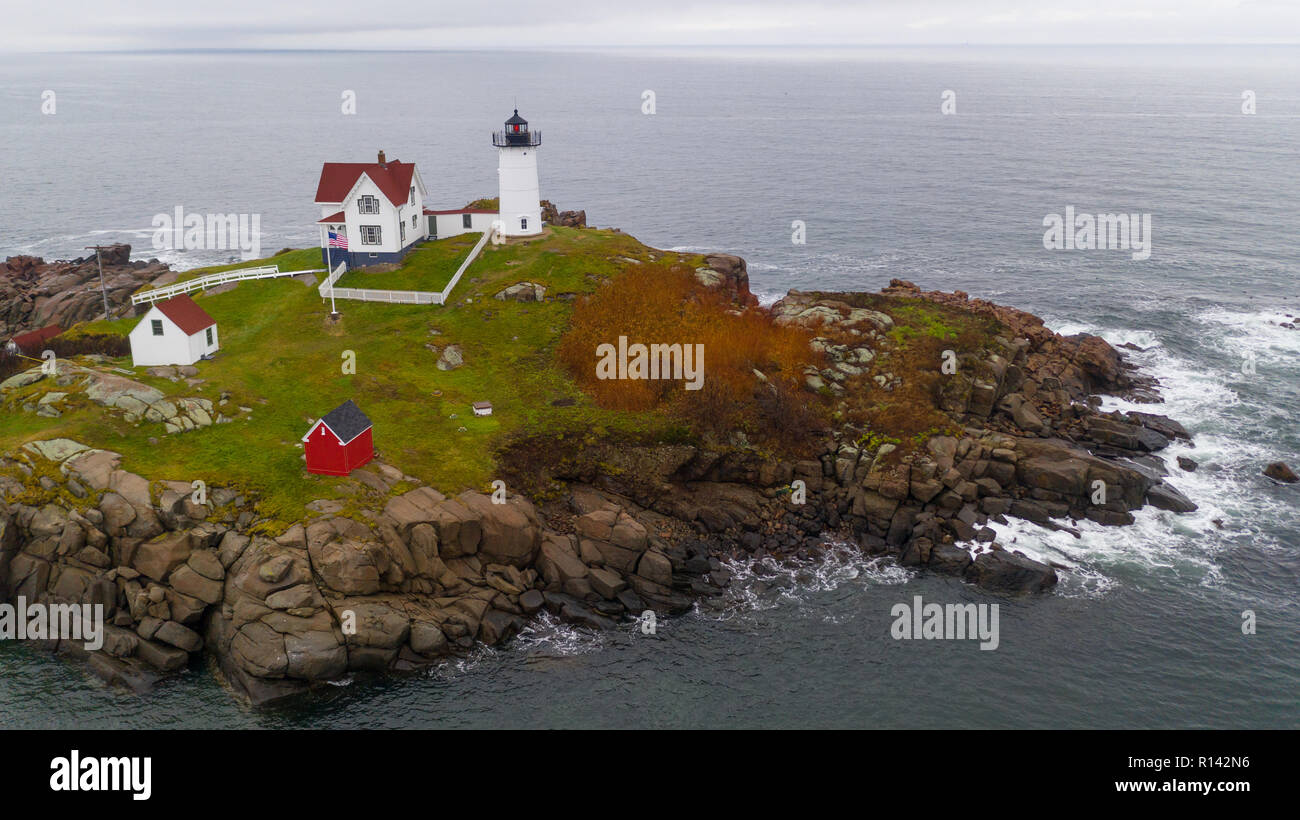 Il rosso faro di luce Nubble avverte i naviganti di rocce pericolose e navigare sull'Oceano Atlantico Costa Orientale Foto Stock