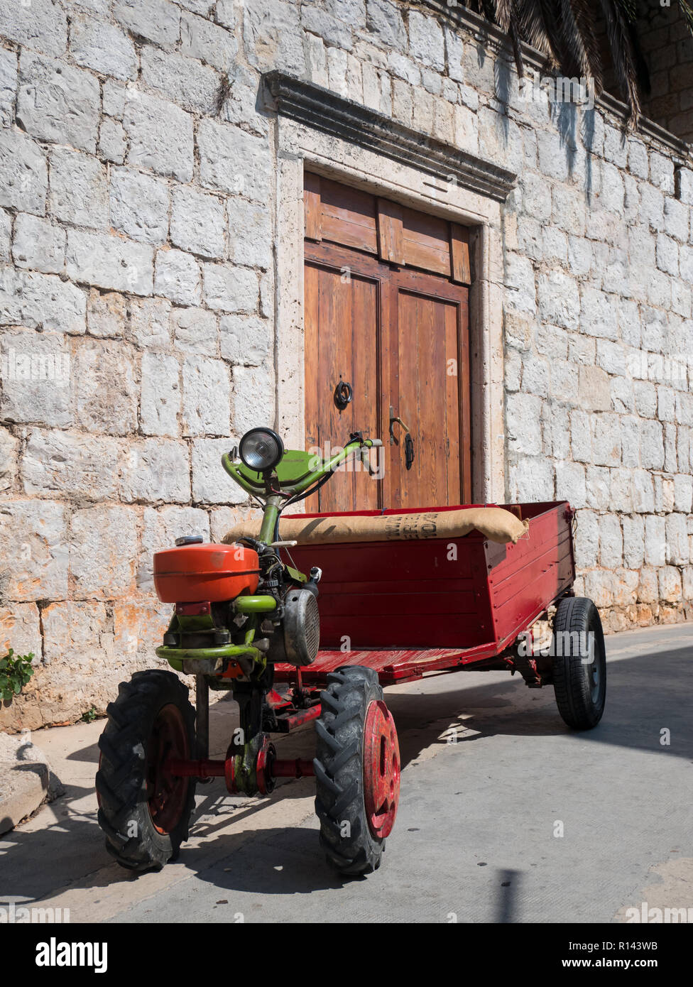 Vintage vecchio trattore davanti casa in pietra sull isola di Vis in Croazia Foto Stock