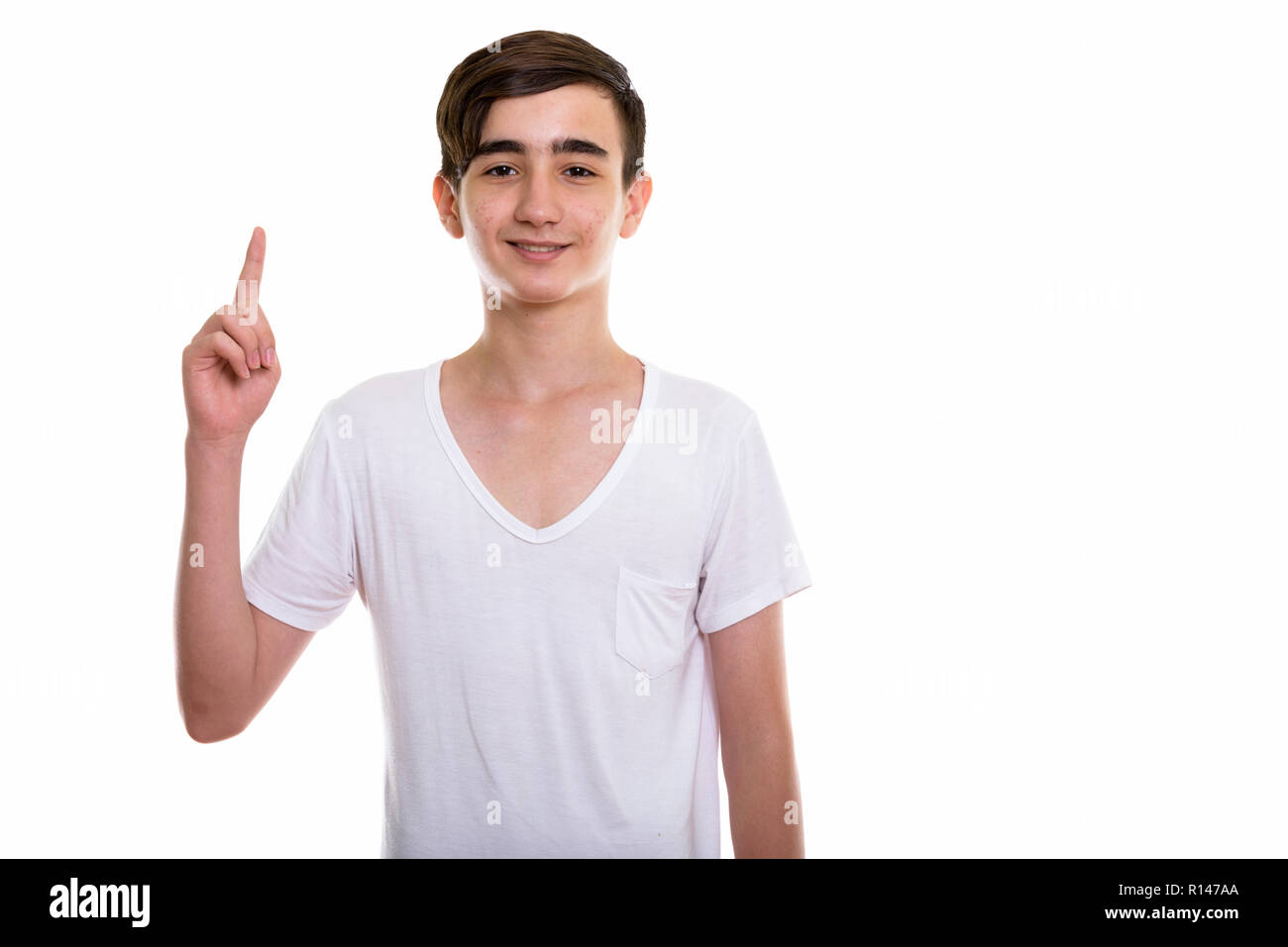 Studio shot di giovani felici persiano di ragazzo adolescente sorridere mentre poi Foto Stock