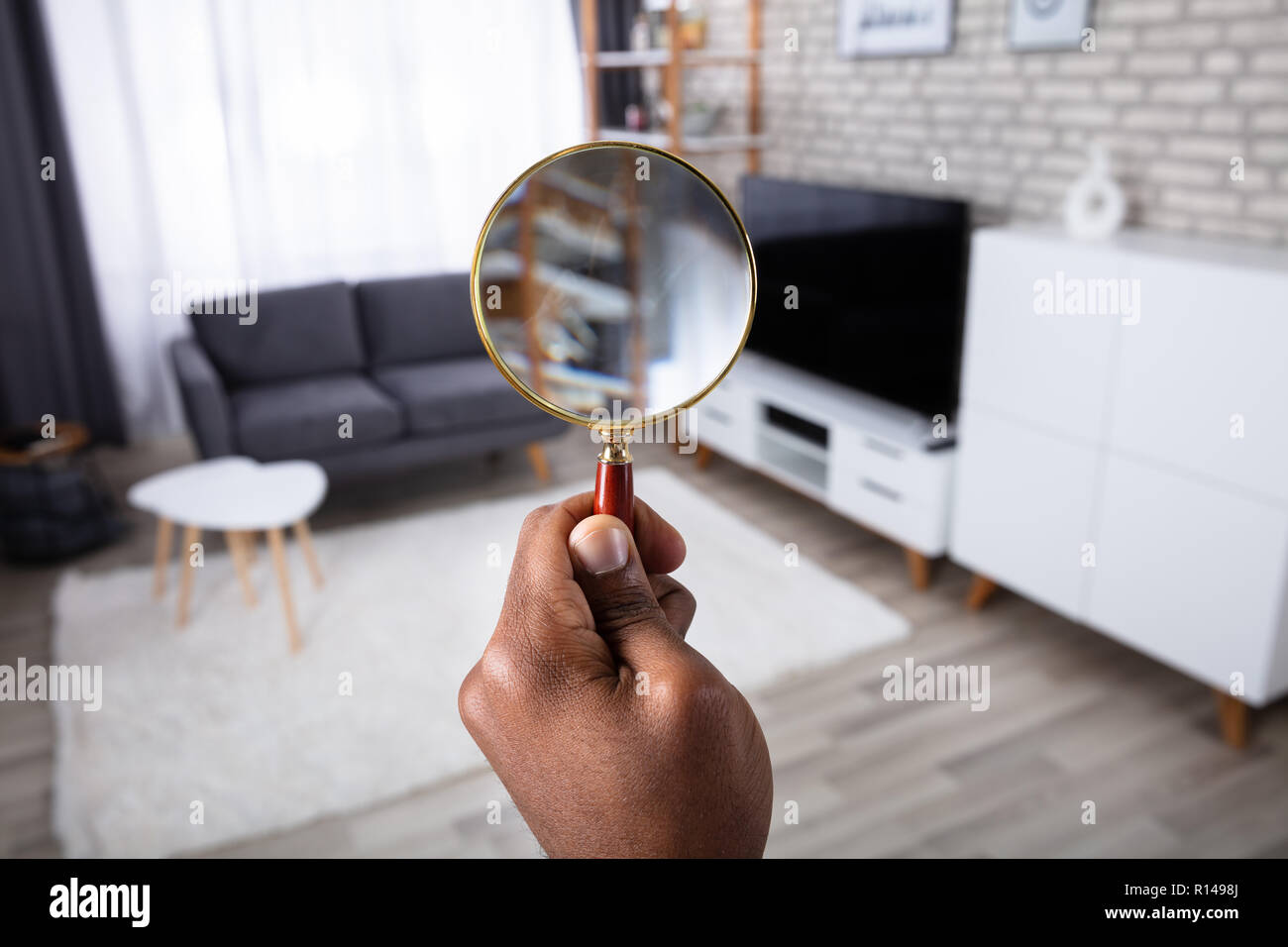 L'uomo alla ricerca della casa con lente di ingrandimento Foto Stock