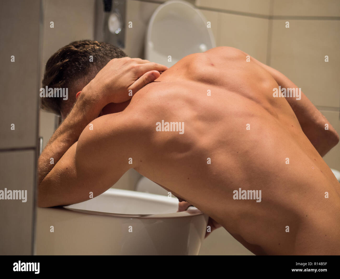 Bevuto Giovane vomito nel wc a casa Foto Stock