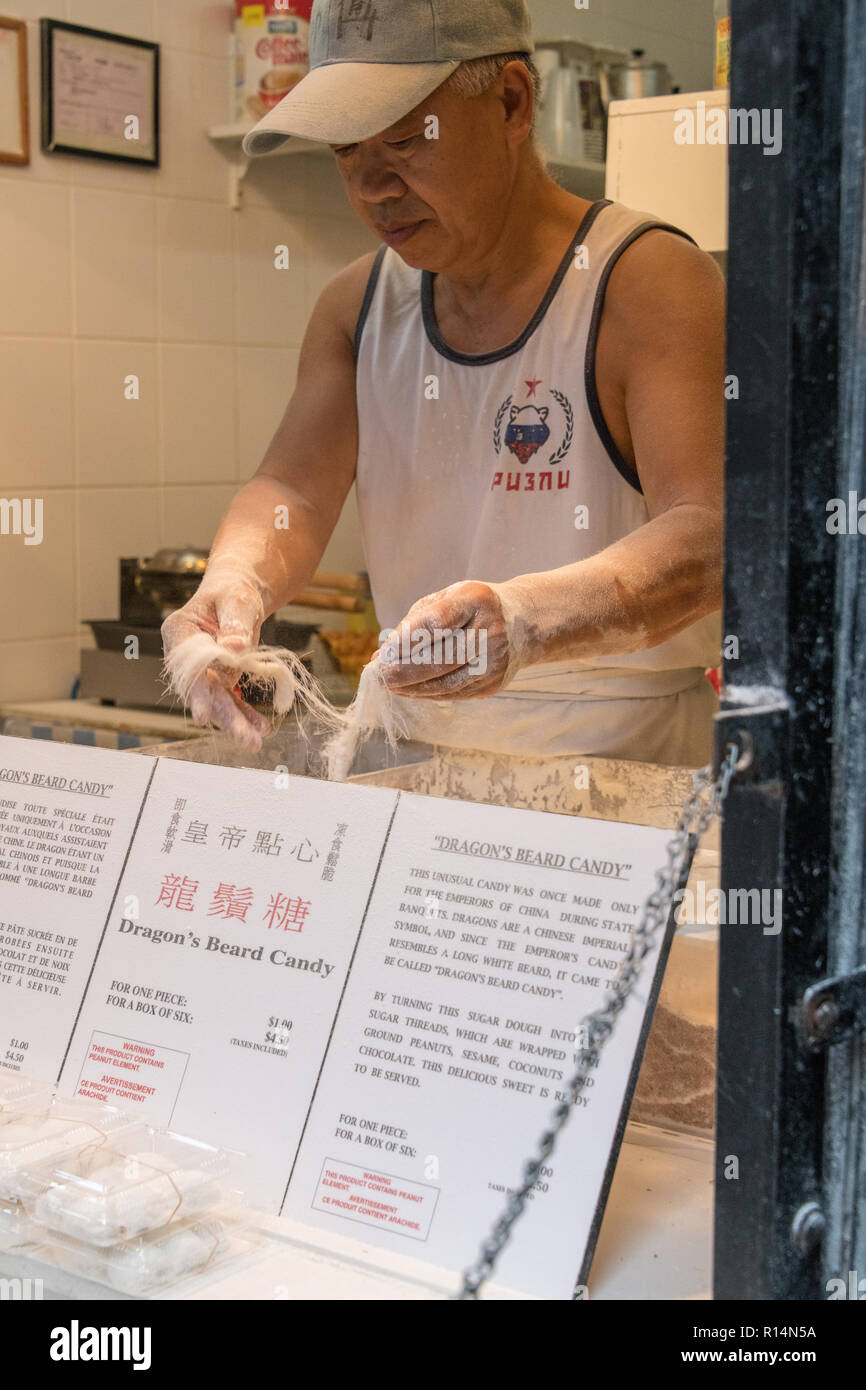 L'uomo rendendo Dragon Barba Candy, Chinatown, Montreal, Canada Foto Stock