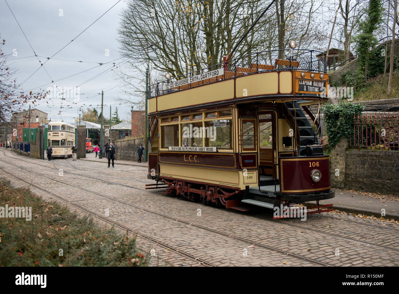 Vintage a sud-est di Londra e Sheffield tram in background sul percorso a Crich tramvia Village, Derbyshire, Regno Unito Foto Stock