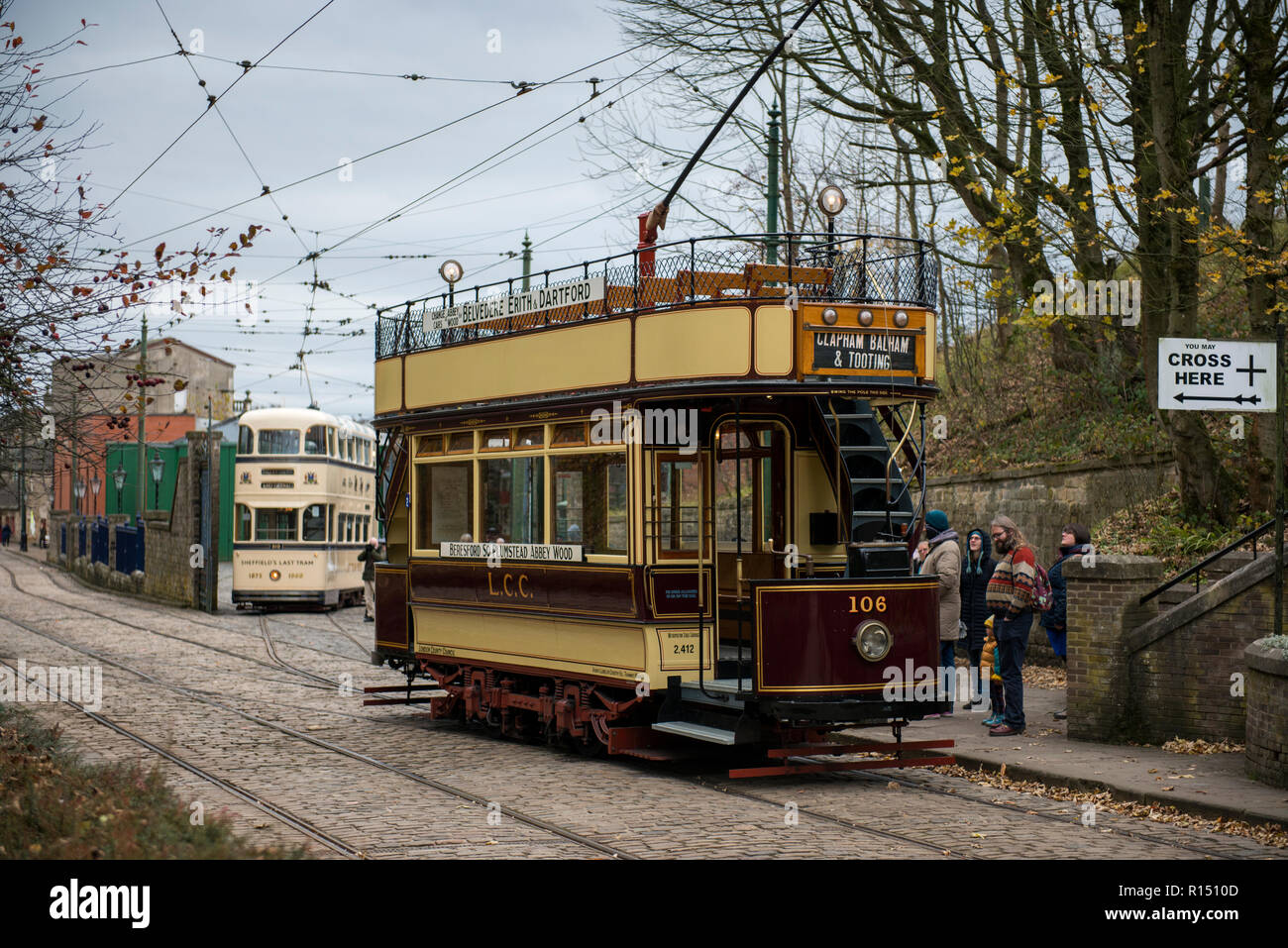 Vintage a sud-est di Londra e Sheffield tram in background sul percorso a Crich tramvia Village, Derbyshire, Regno Unito Foto Stock