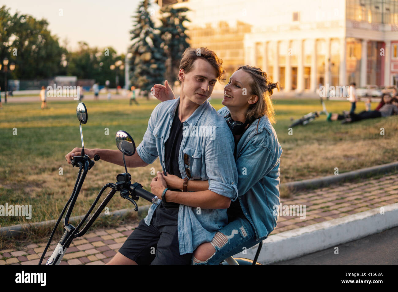 Bella coppia Giovane la guida elettrica bici in estate Foto Stock