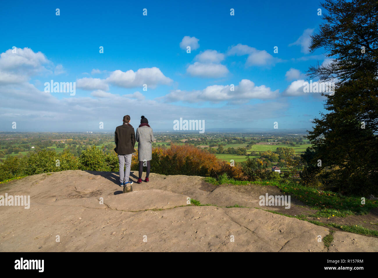 Coppia giovane stava guardando la campagna di Cheshire da Alderley Edge, Cheshire, Inghilterra. Foto Stock