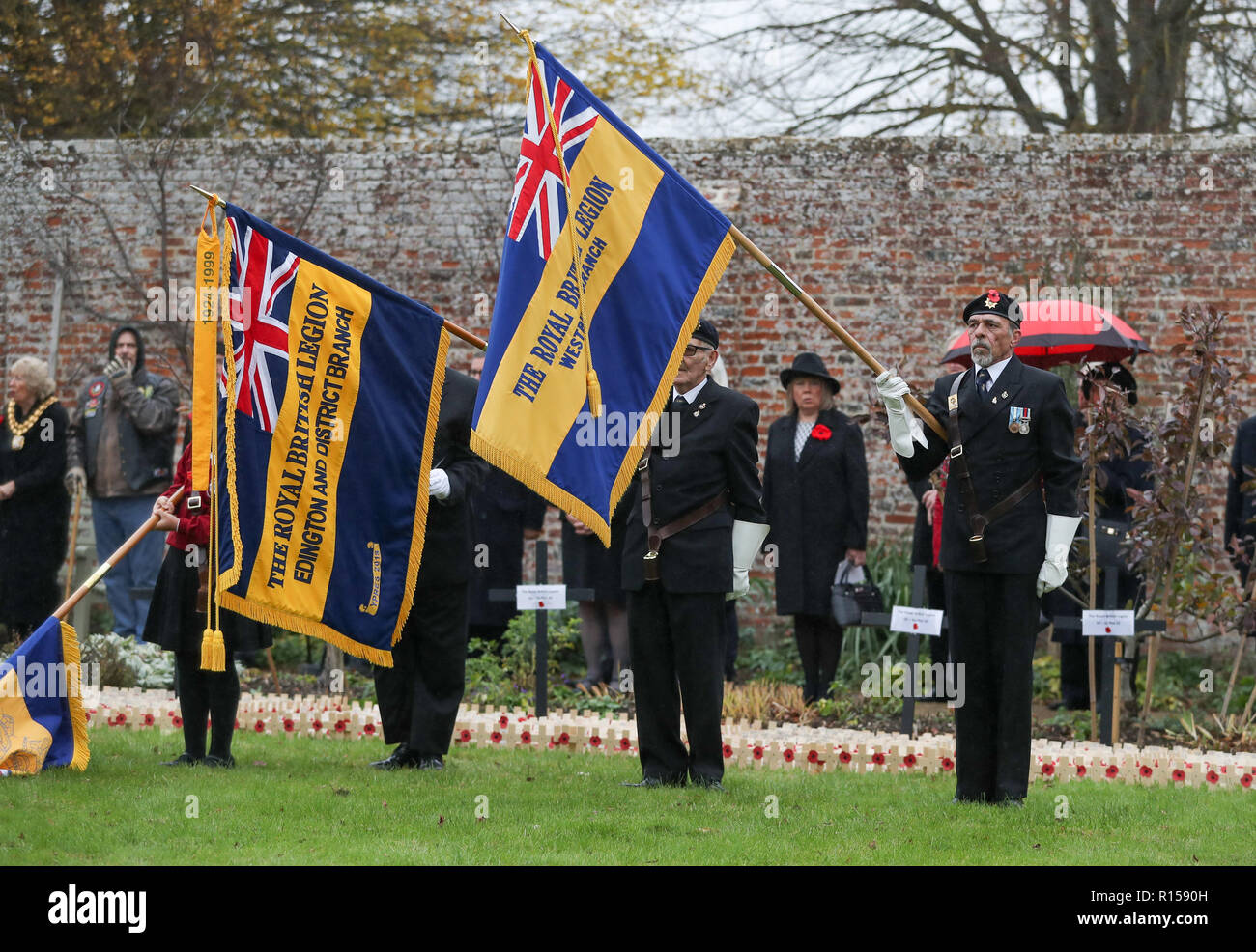 I membri della Royal British Legion abbassare le loro norme per l'Inno Nazionale durante l'apertura ufficiale del campo di ricordo presso il Royal Wootton Bassett, nella motivazione di Lydiard House e Parco, Swindon. Foto Stock