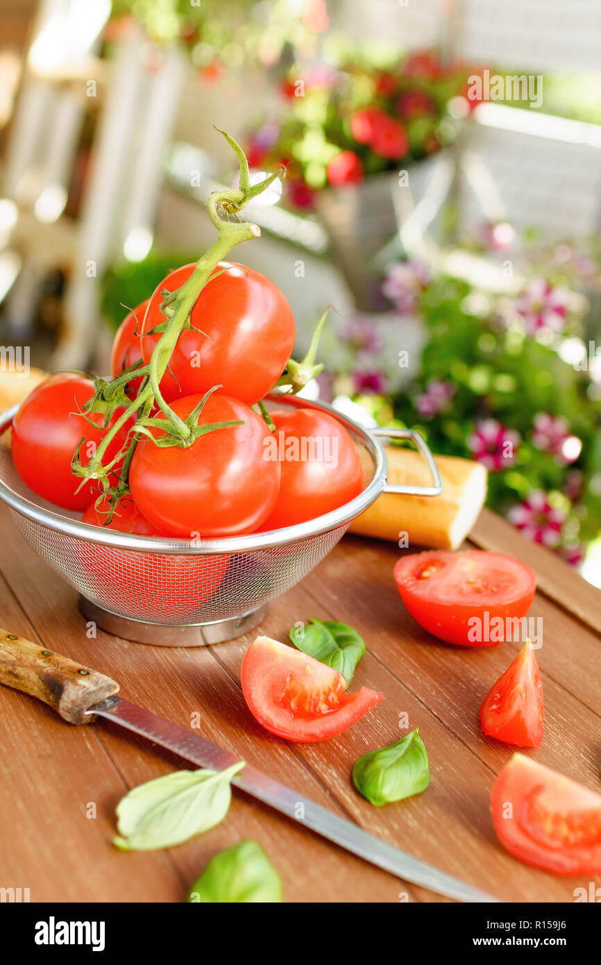 Pomodori freschi giacente in un setaccio da cucina su un vassoio in legno Foto Stock