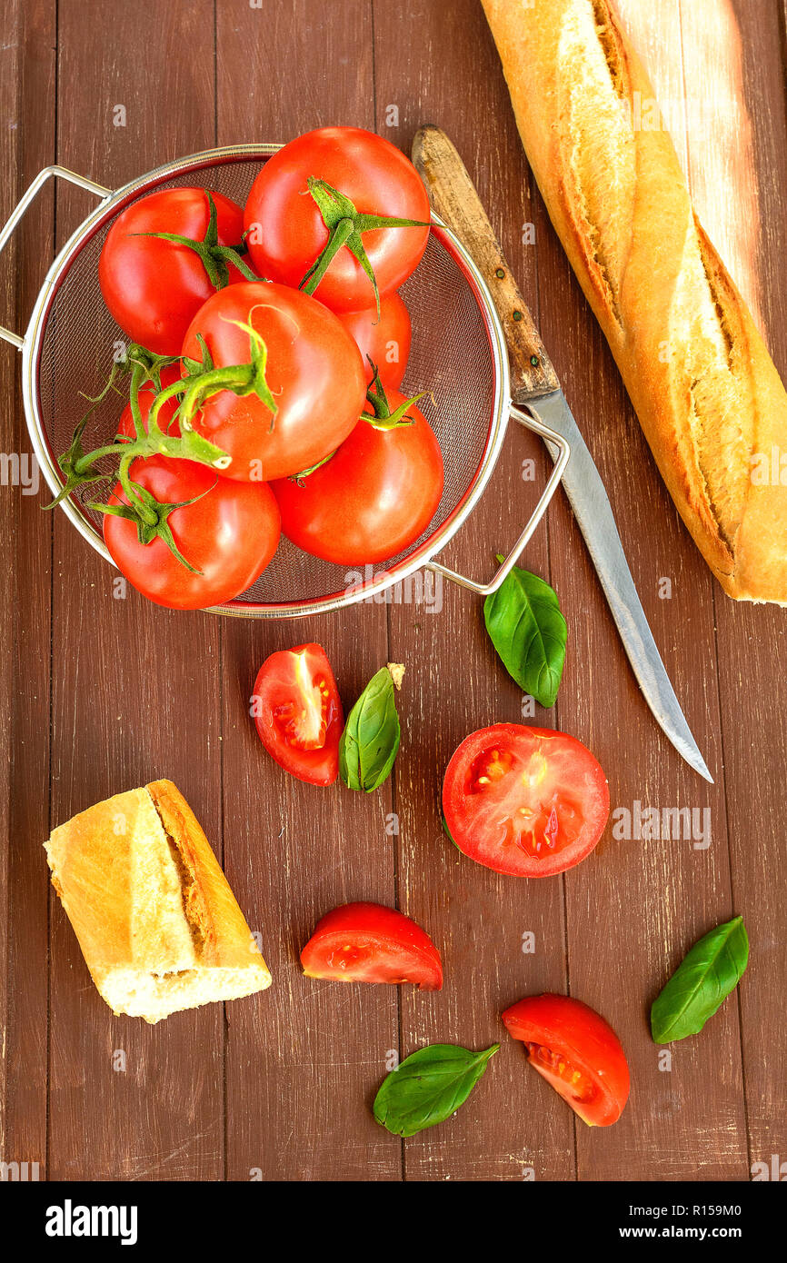 Pomodori freschi giacente in un setaccio da cucina su un vassoio in legno Foto Stock