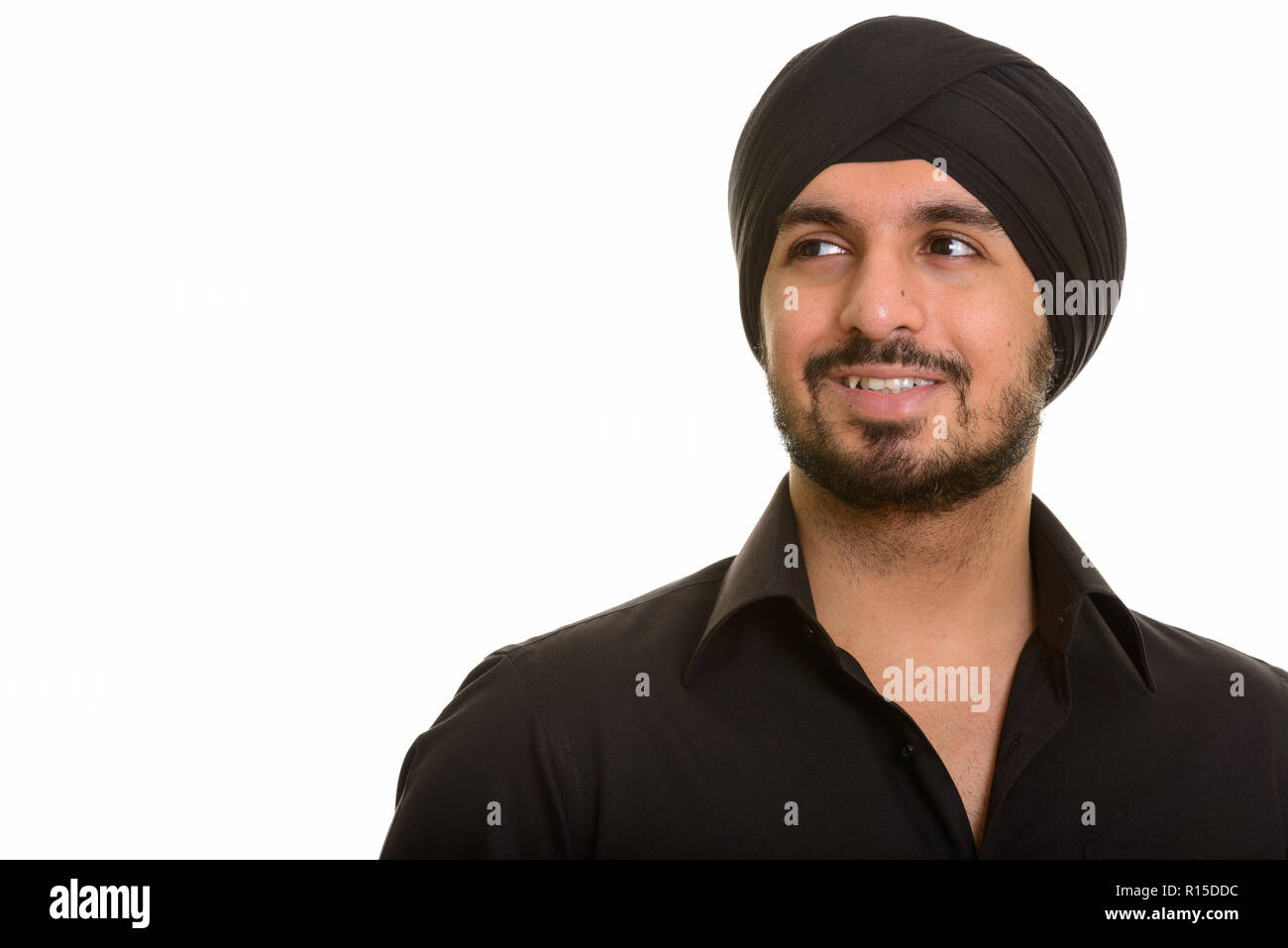 Ritratto di giovane felice indiano uomo Sikh pensando Foto Stock