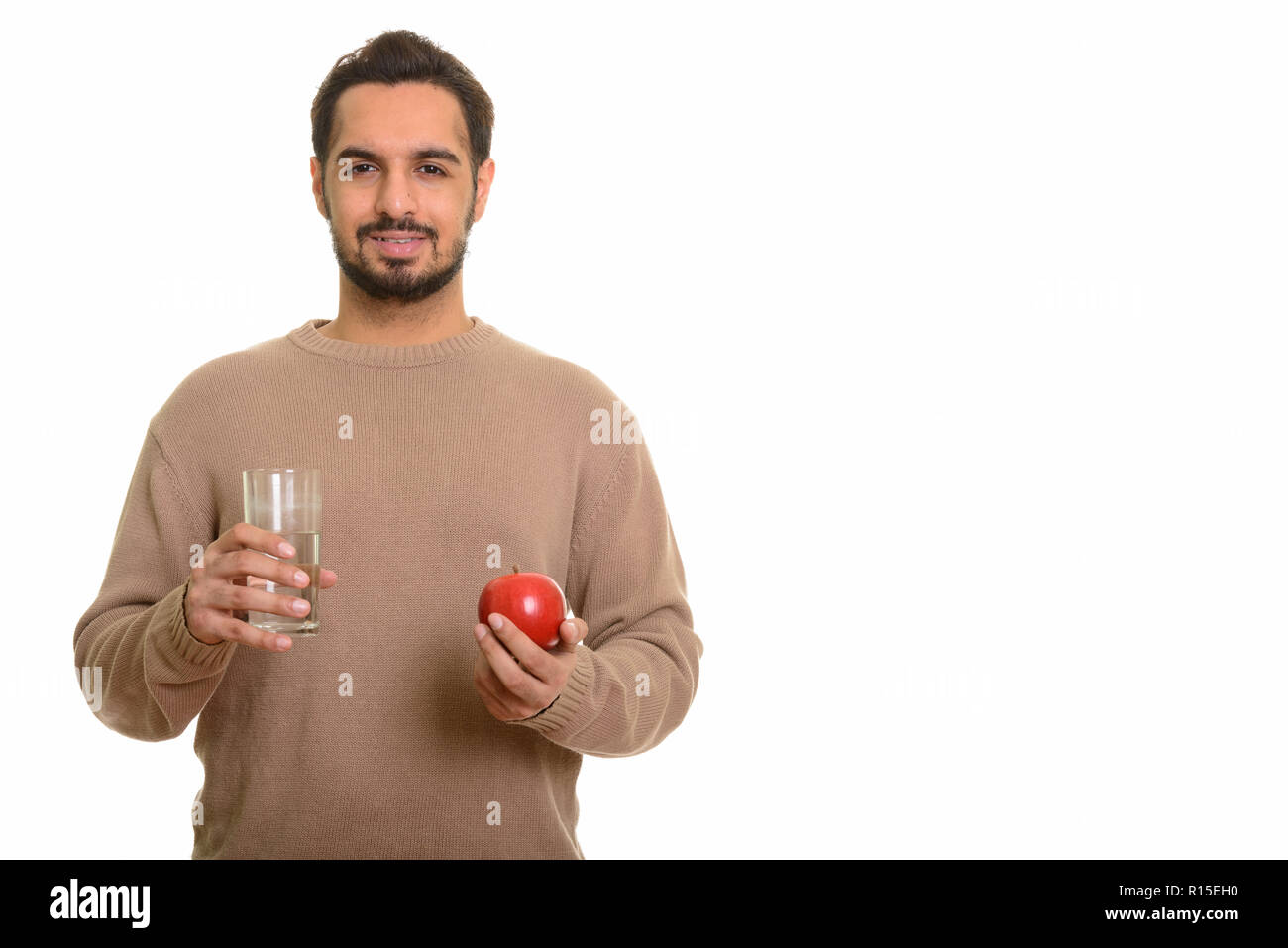 Giovani indiani felici uomo azienda red apple e un bicchiere di acqua Foto Stock