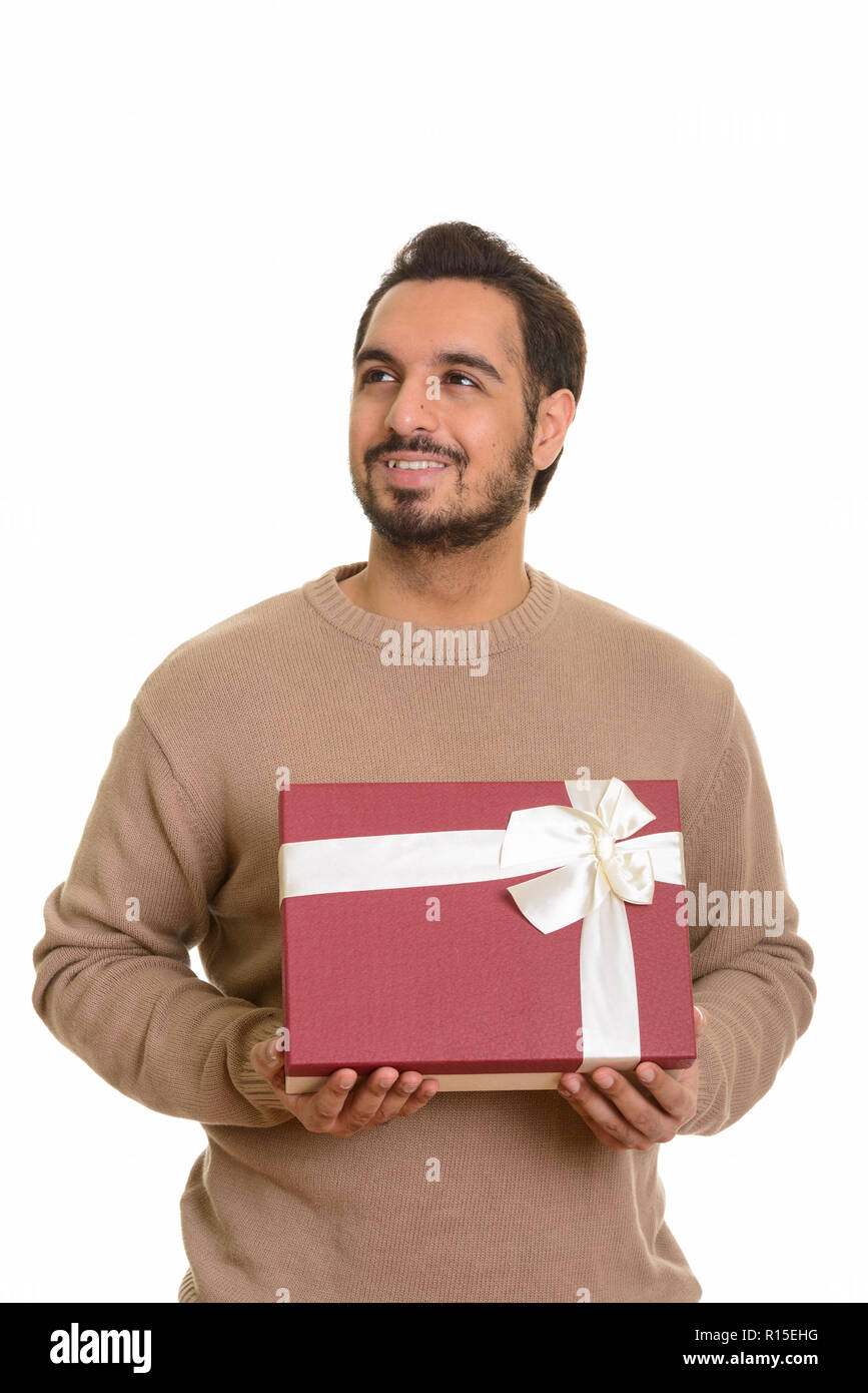 Giovani indiani felici uomo azienda confezione regalo mentre pensando pronto per Foto Stock