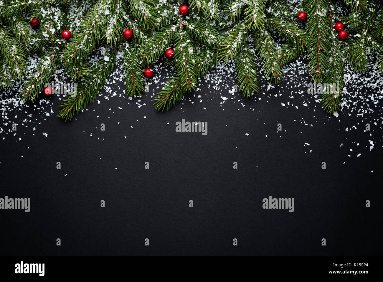 Buon Natale e felice anno nuovo. Holiday sfondo con copia spazio per il testo. Decorazioni con rami di abete e di agrifoglio bacche di neve. Piatto, laici vista superiore Foto Stock