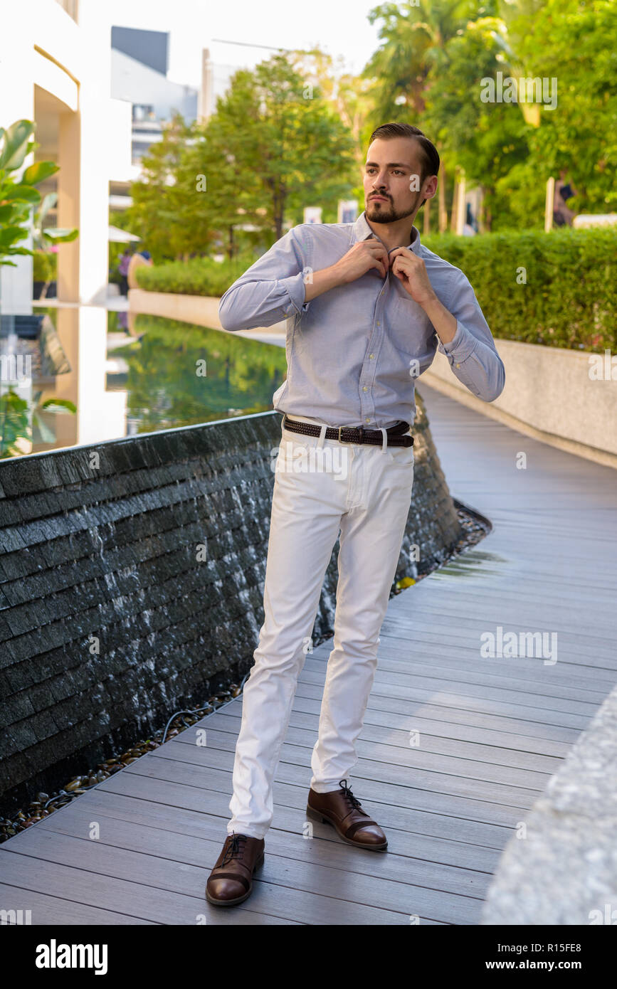 Ritratto di giovane barbuto di moda uomo all'aperto Foto Stock