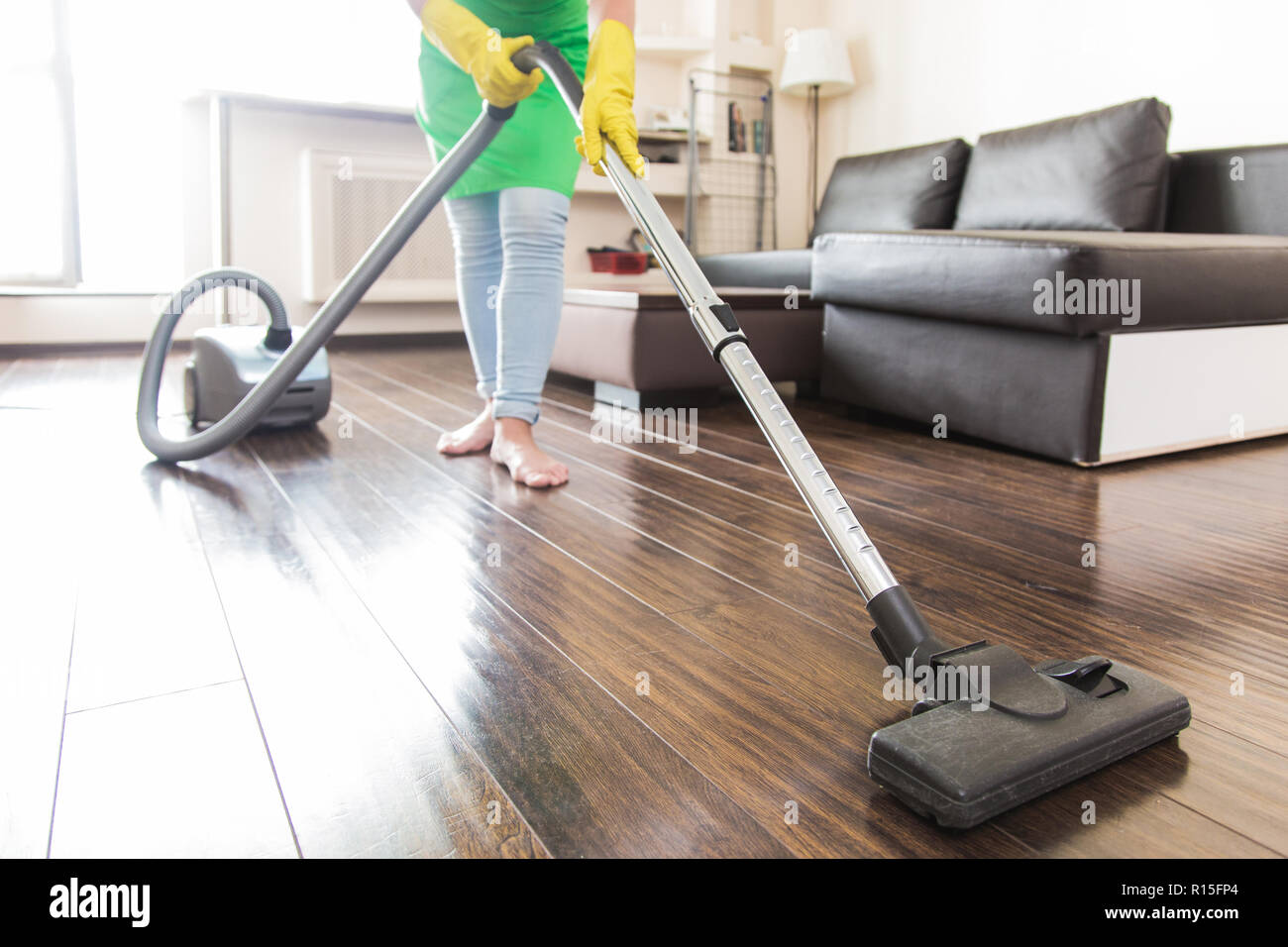 Il servizio di pulizia. La rimozione di polvere con un aspirapolvere.  pavimento pulito a casa Foto stock - Alamy