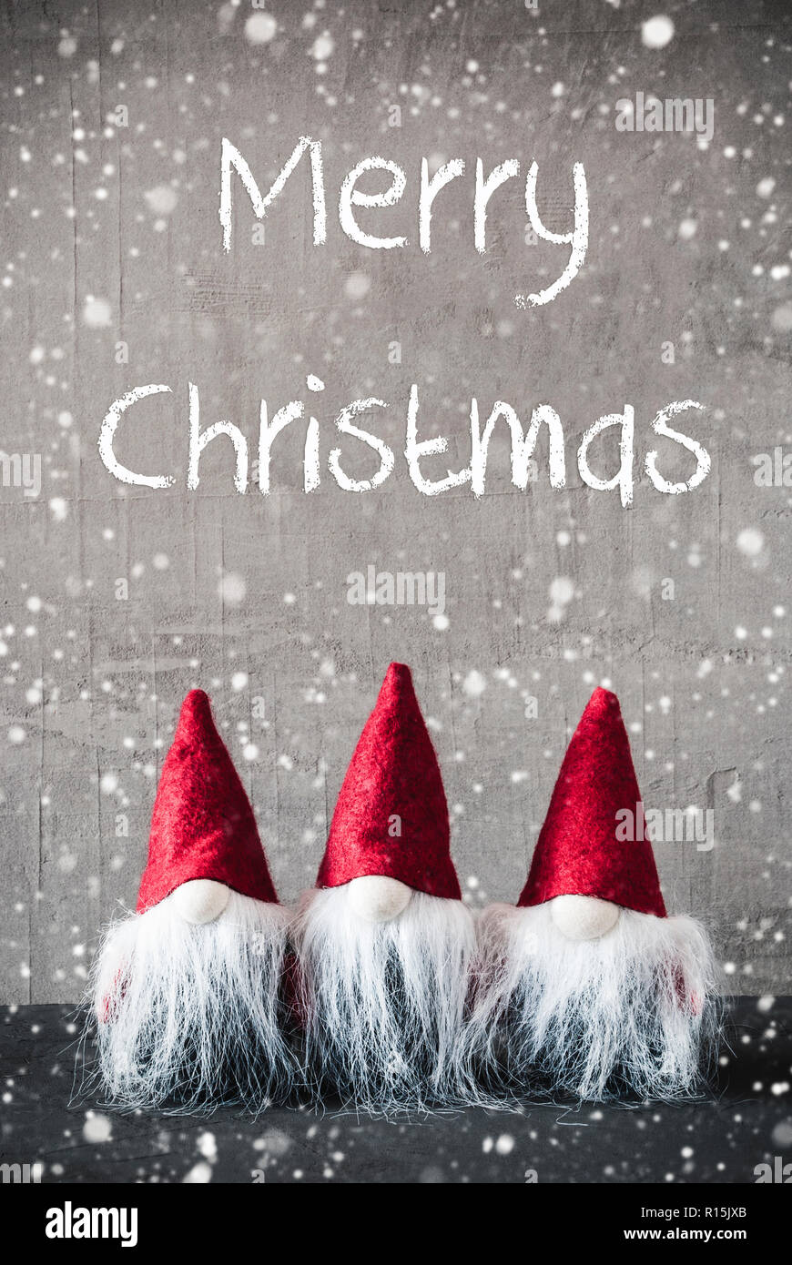 Tre gnomi rosso, cemento, i fiocchi di neve, Testo Buon Natale Foto Stock