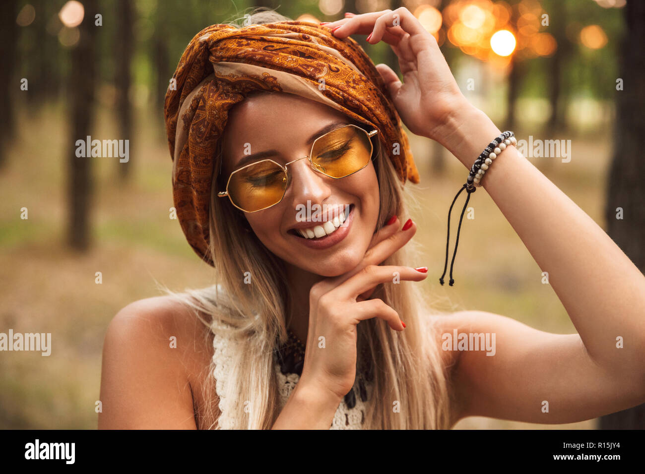 Foto di gioiosa hippie donna che indossa gli eleganti accessori sorridere  mentre passeggiate in foresta Foto stock - Alamy
