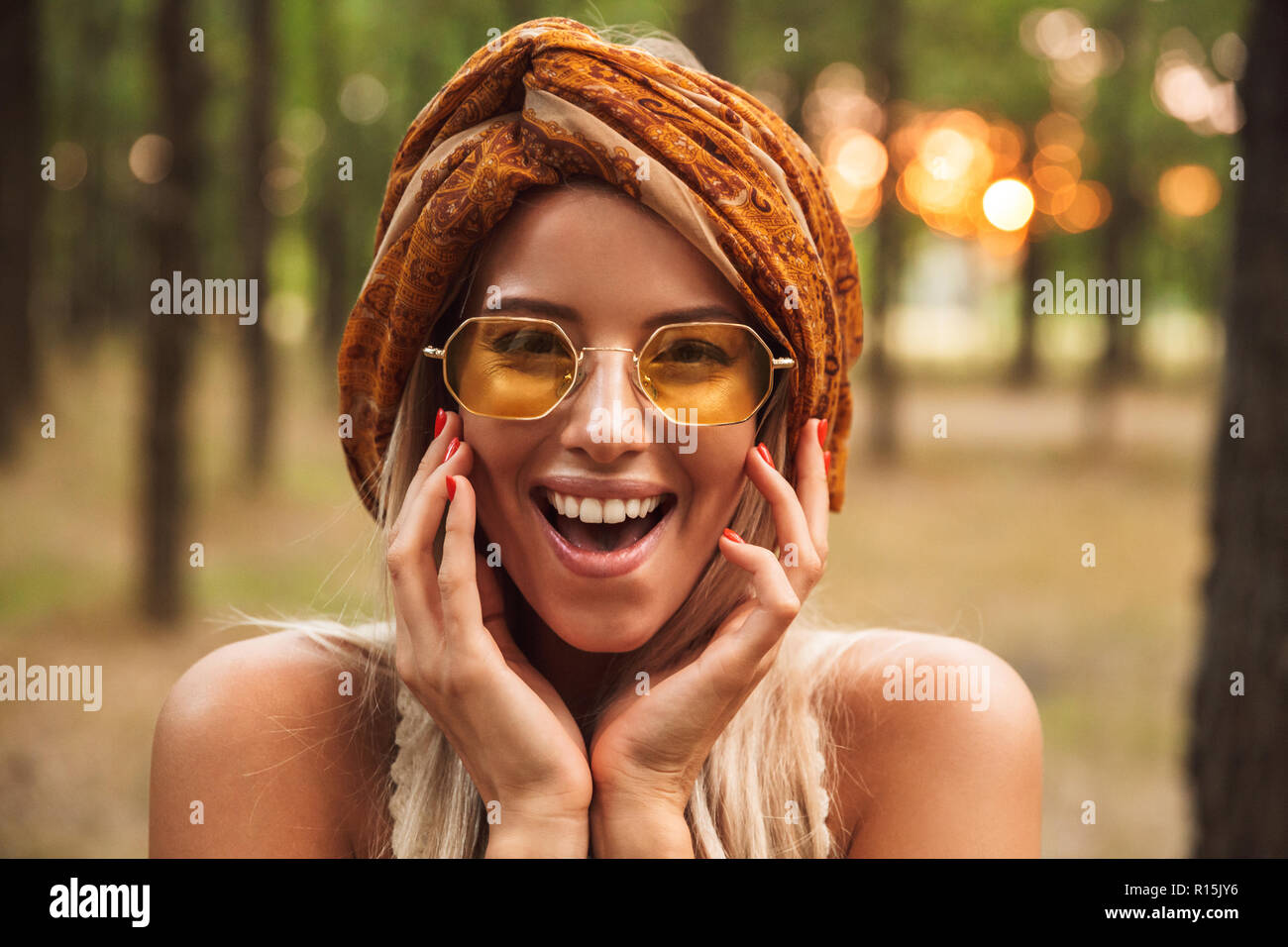 Foto di allegro hippie donna che indossa gli eleganti accessori sorridere mentre passeggiate in foresta Foto Stock