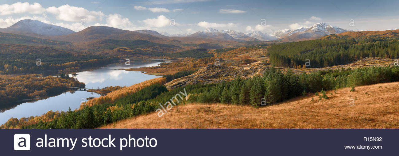 Una vista panoramica che si affaccia su un a Loch Garry e innevate montagne Knoydart durante una soleggiata giornata autunnale Foto Stock