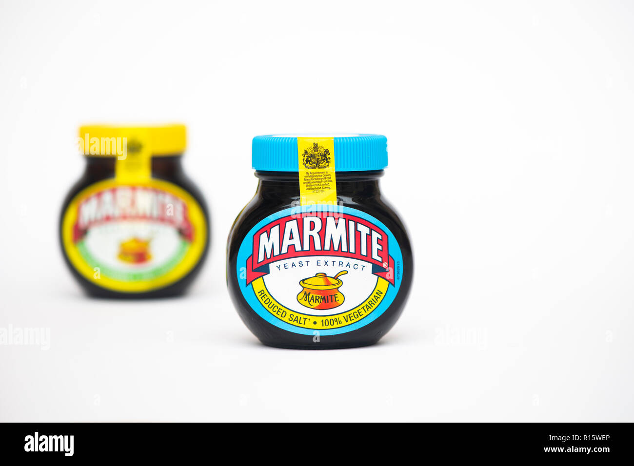 Originale di marmite e ridotto il sale della marmite su sfondo bianco Foto Stock