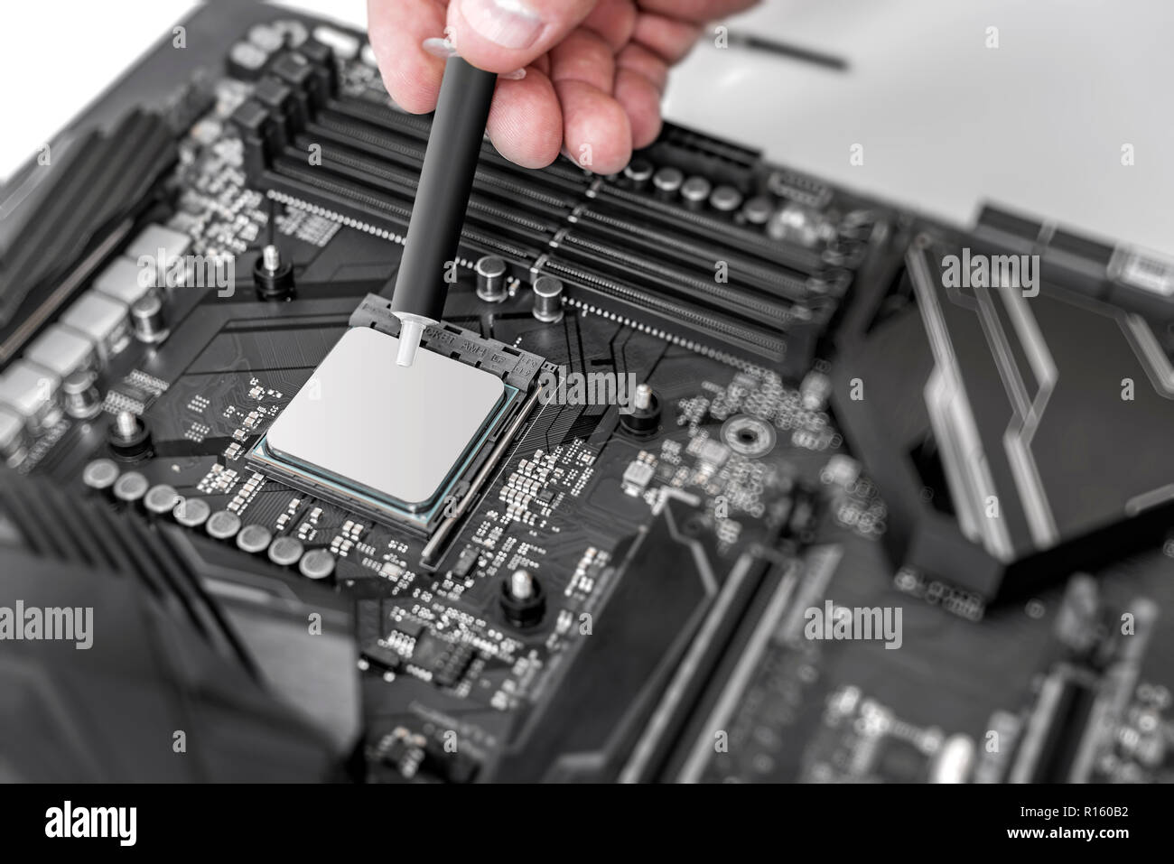 Ingegnere di applicare la pasta termica sul computer su chip della scheda cpu. Foto Stock