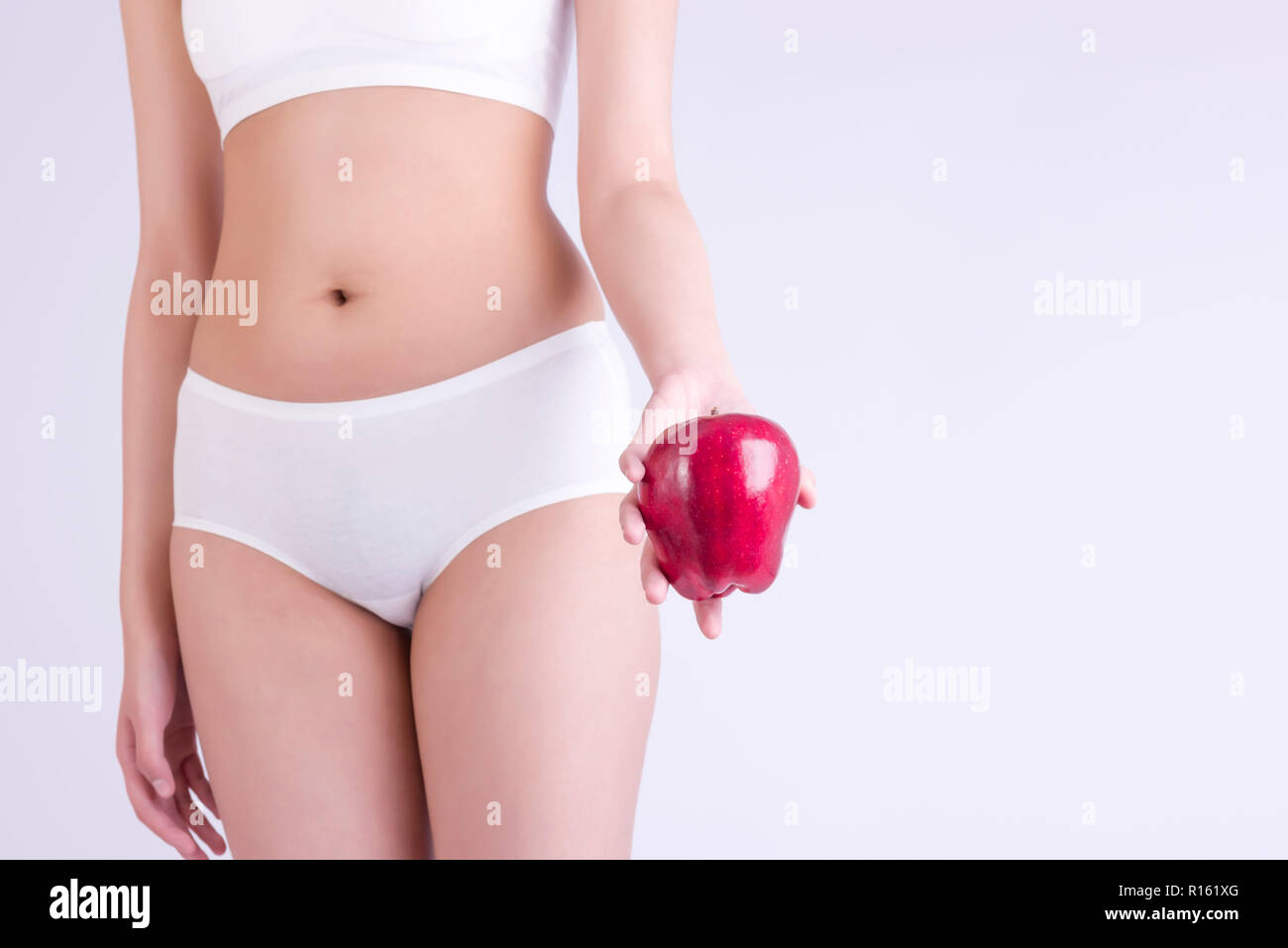 Donna che mantiene un fresh apple e perfetto corpo sottile, dieta, uno stile di vita sano. Foto Stock