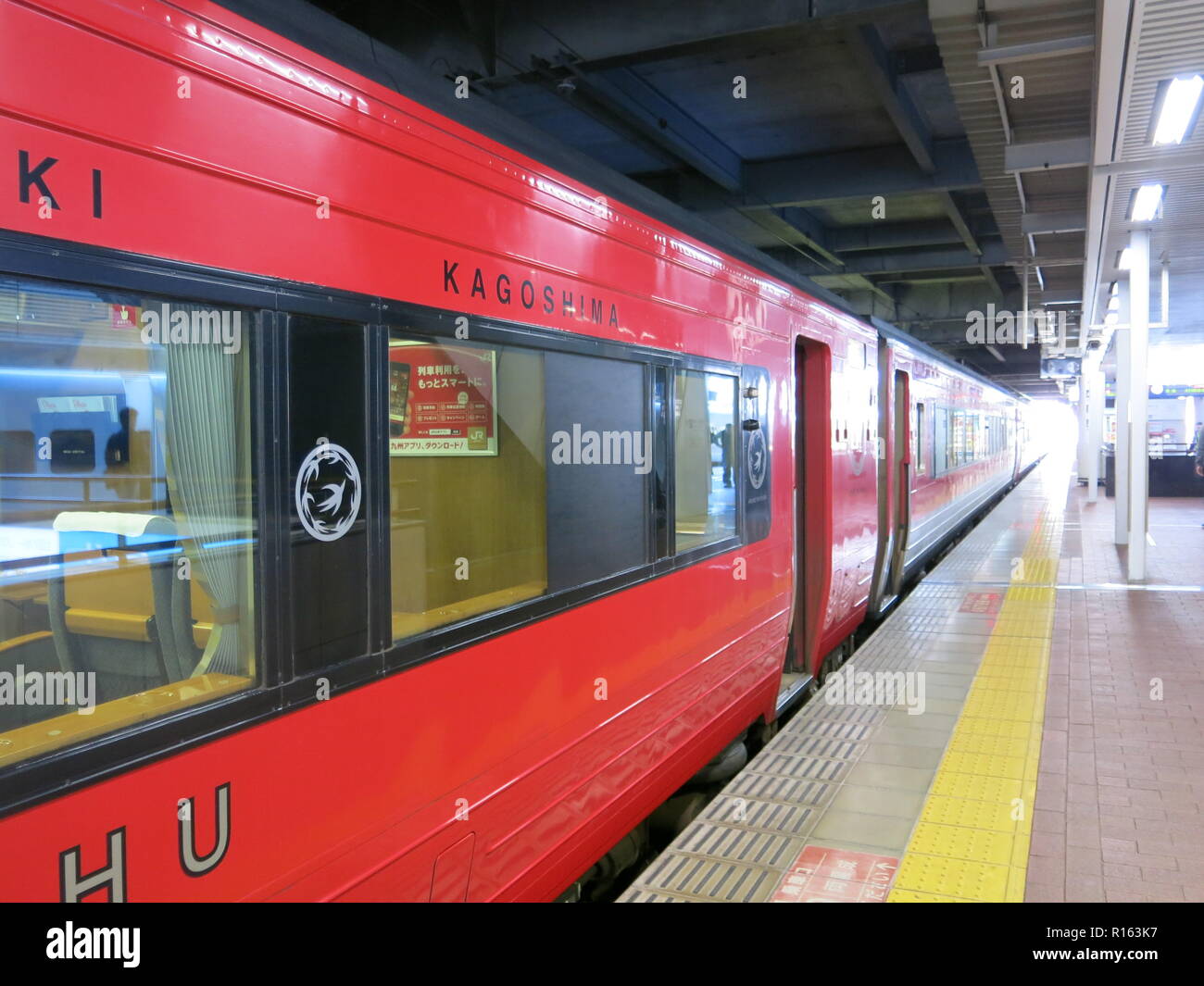 Un trenino rosso del trasporto della Trans Kyushu Ltd Express presso la piattaforma presso la Stazione di Hakata, Giappone Foto Stock