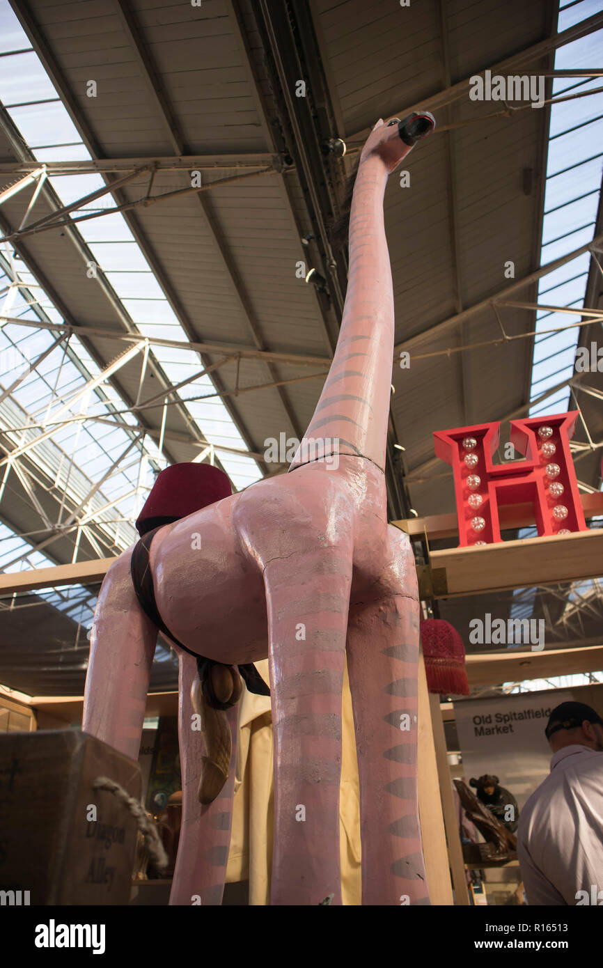 Londra, Inghilterra - 15 settembre 2018 coperti Old Spitalfields Market a Tower Hamlets. Rosa giraffa in legno Foto Stock