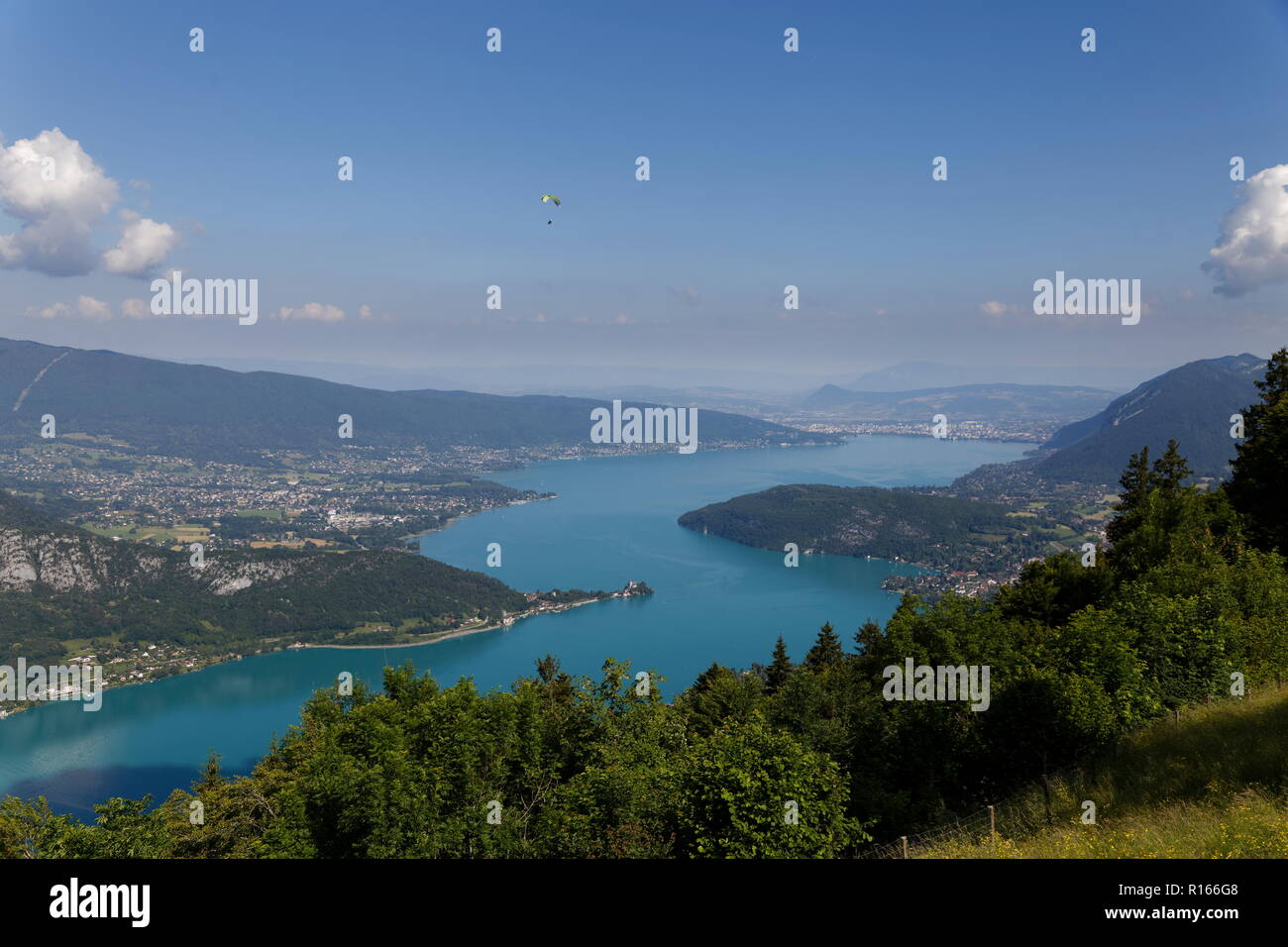 Singolo parapendio volare sopra le acque turchesi del lago di Annecy Francia Foto Stock