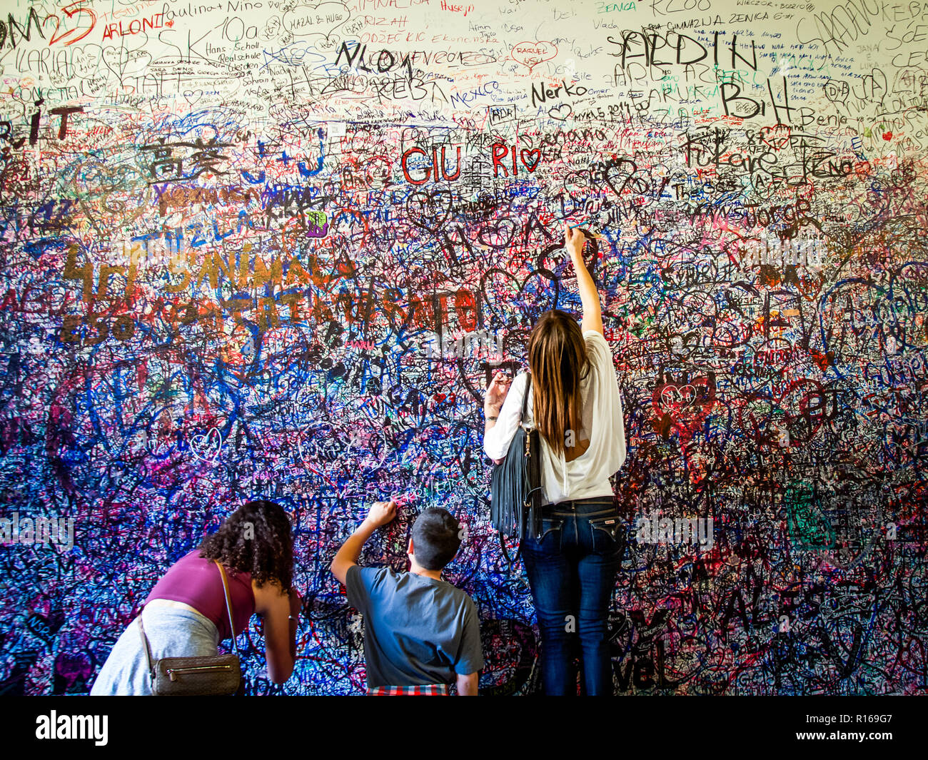 I turisti di scrivere messaggi sul muro della casa di Giulietta a Verona, Italia Foto Stock