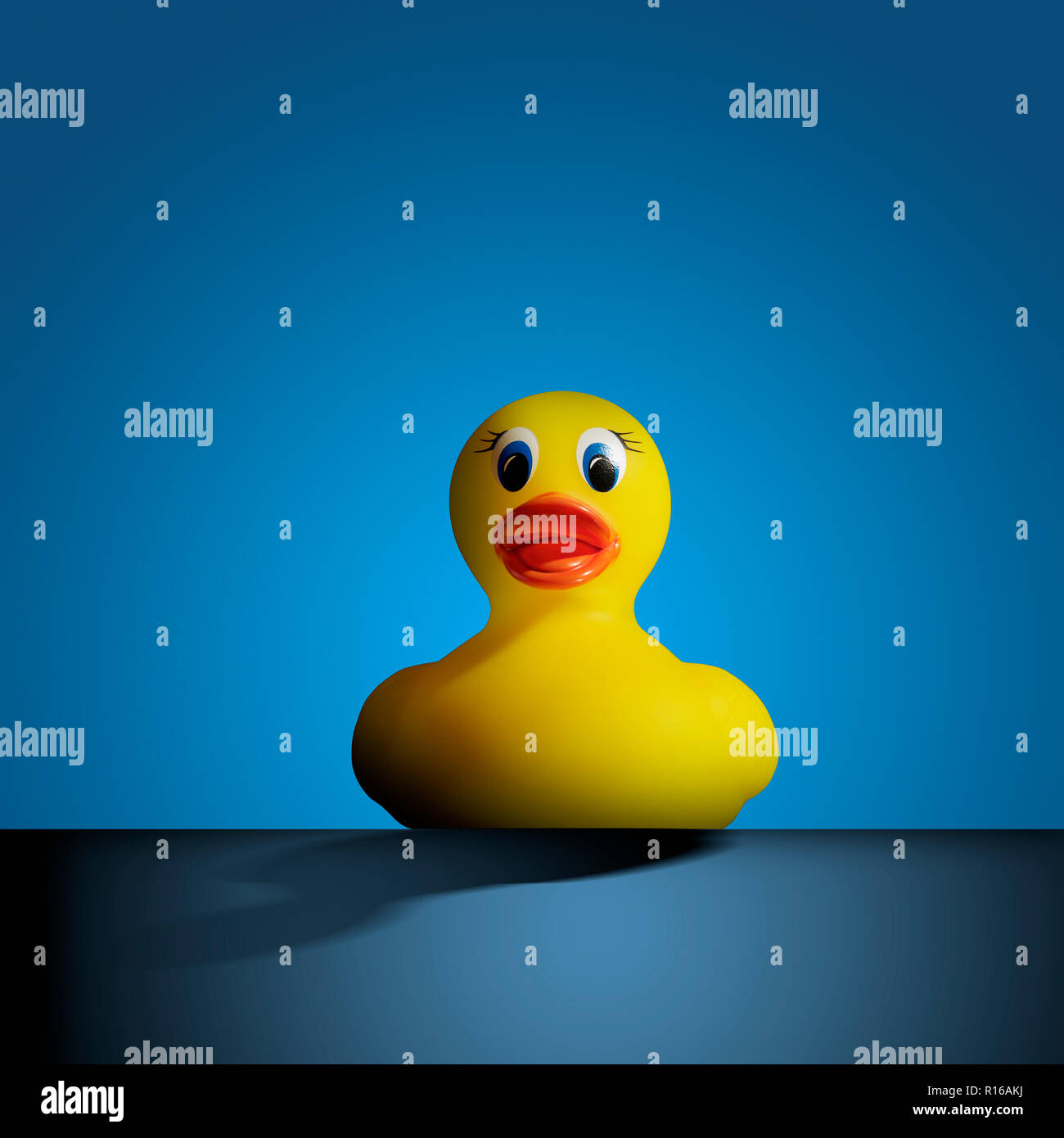 Gomma gialla duck contro sfondo blu, vista frontale Foto Stock