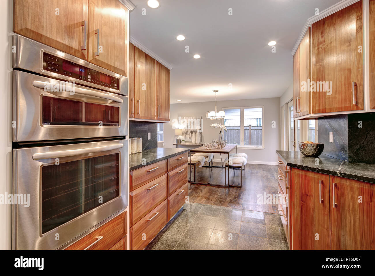 Lussuosa camera cucina con elettrodomestici in acciaio inox, contatore scuro cime e pavimento piastrellato. Foto Stock
