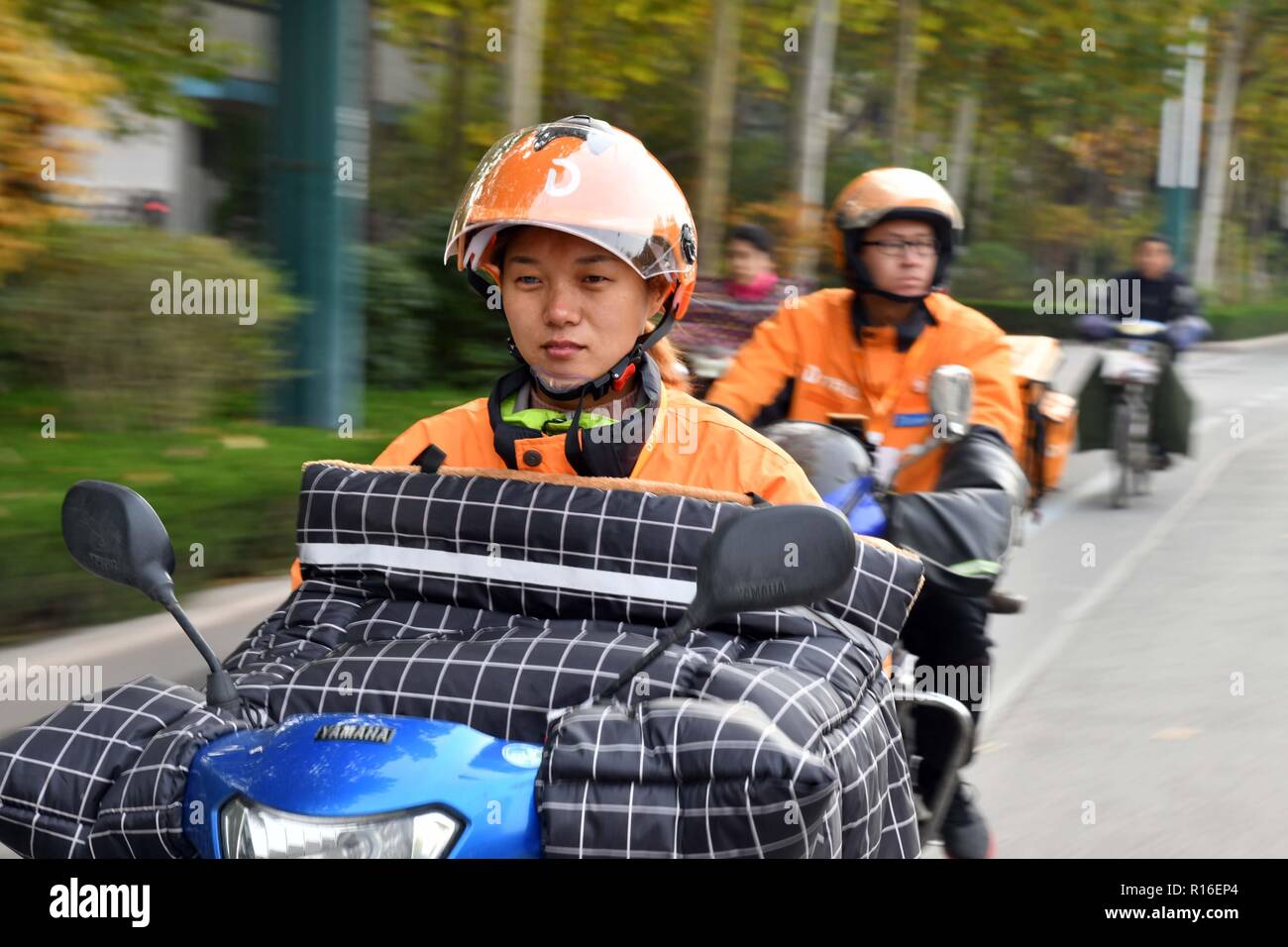 (181109) -- JINAN, nov. 9, 2018 (Xinhua) -- Non udenti consegna rider Gao li distribuisce alimenti nel distretto di Kuiwen di Weifang, est della Cina di Provincia di Shandong, nov. 8, 2018. Un outsourcing di instant delivery service provider in Weifang è riuscito a impiegare più di trenta non udenti piloti che, dopo pertinenti corsi di formazione professionale, si stanno rivelando se stessi ugualmente competenti come i loro coetanei senza perdita di udito. La società non udenti team di consegna consiste di piloti provenienti da diverse culture: college graduate, madre single, ex allenatore di guida e gli altri. E la gamma dei loro ser Foto Stock