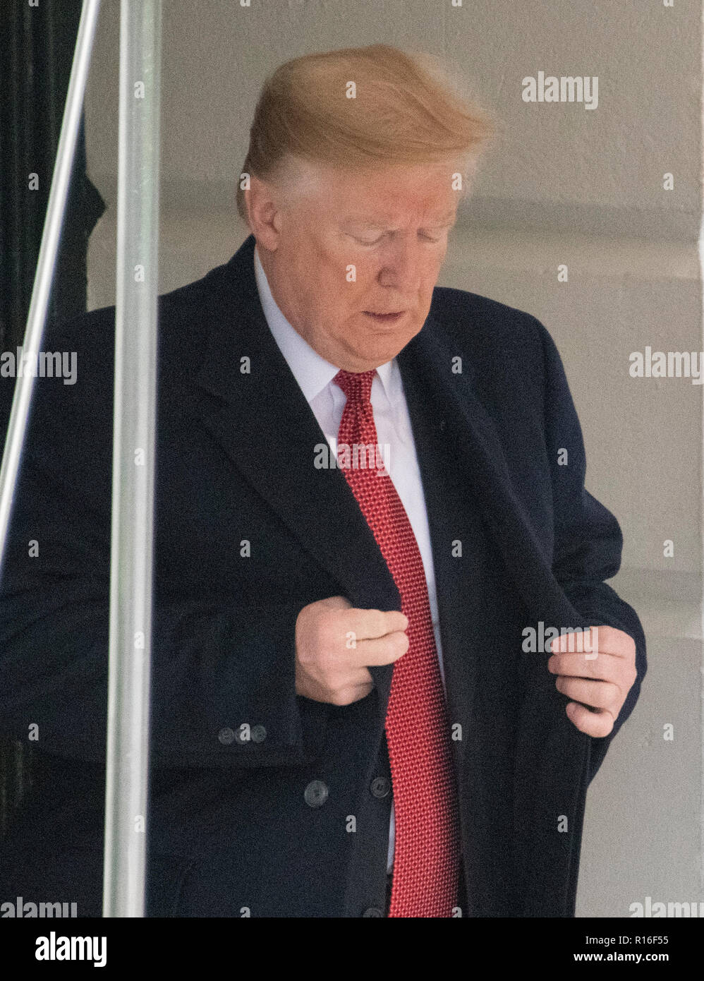 Il Presidente degli Stati Uniti, Trump regola il suo mantello come egli prepara partono il South Lawn della Casa Bianca di Washington, DC il Venerdì, 9 novembre 2018 in rotta per Parigi e la Francia dove potranno partecipare alle celebrazioni per il centesimo anniversario della fine della Seconda guerra mondiale I. Credito: Ron Sachs/CNP | Utilizzo di tutto il mondo Foto Stock