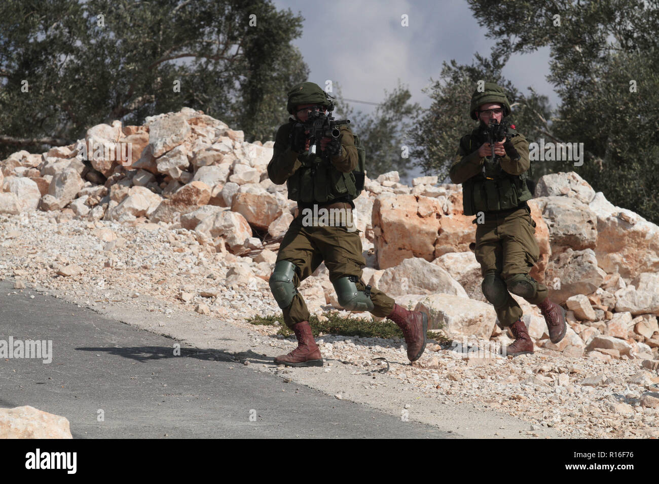 Nablus. 9 Nov, 2018. Soldato israeliano obiettivo le loro armi a dimostranti palestinesi durante scontri dopo una manifestazione di protesta contro l'espansione degli insediamenti ebraici in Kufr Qadoom villaggio vicino alla Cisgiordania città di Nablus, su nov. 9, 2018. Credito: Nidal Eshtayeh/Xinhua/Alamy Live News Foto Stock