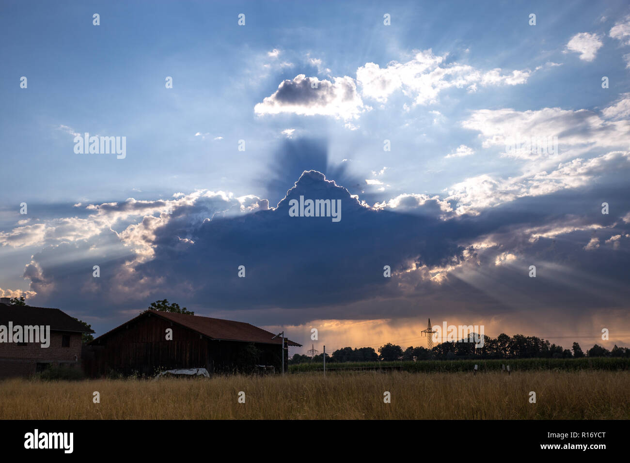 Cambio del tempo con raggi di sole sopra il campo con Capanna, Germania. Foto Stock