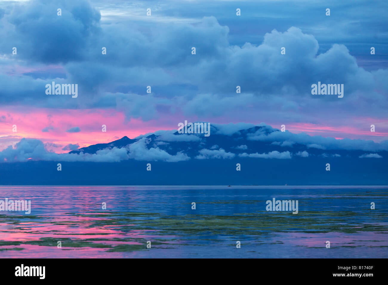 Bella Blu crepuscolo tramonto nelle Filippine con la rosa, blu e viola i colori del cielo si riflette nella calma oceano tranquillo sotto contro Foto Stock