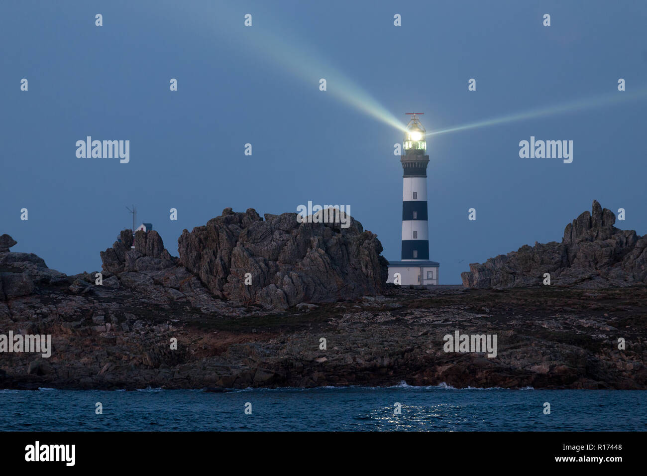 Potente faro illuminato al crepuscolo, creach punto, isola di Ushant, Francia Foto Stock