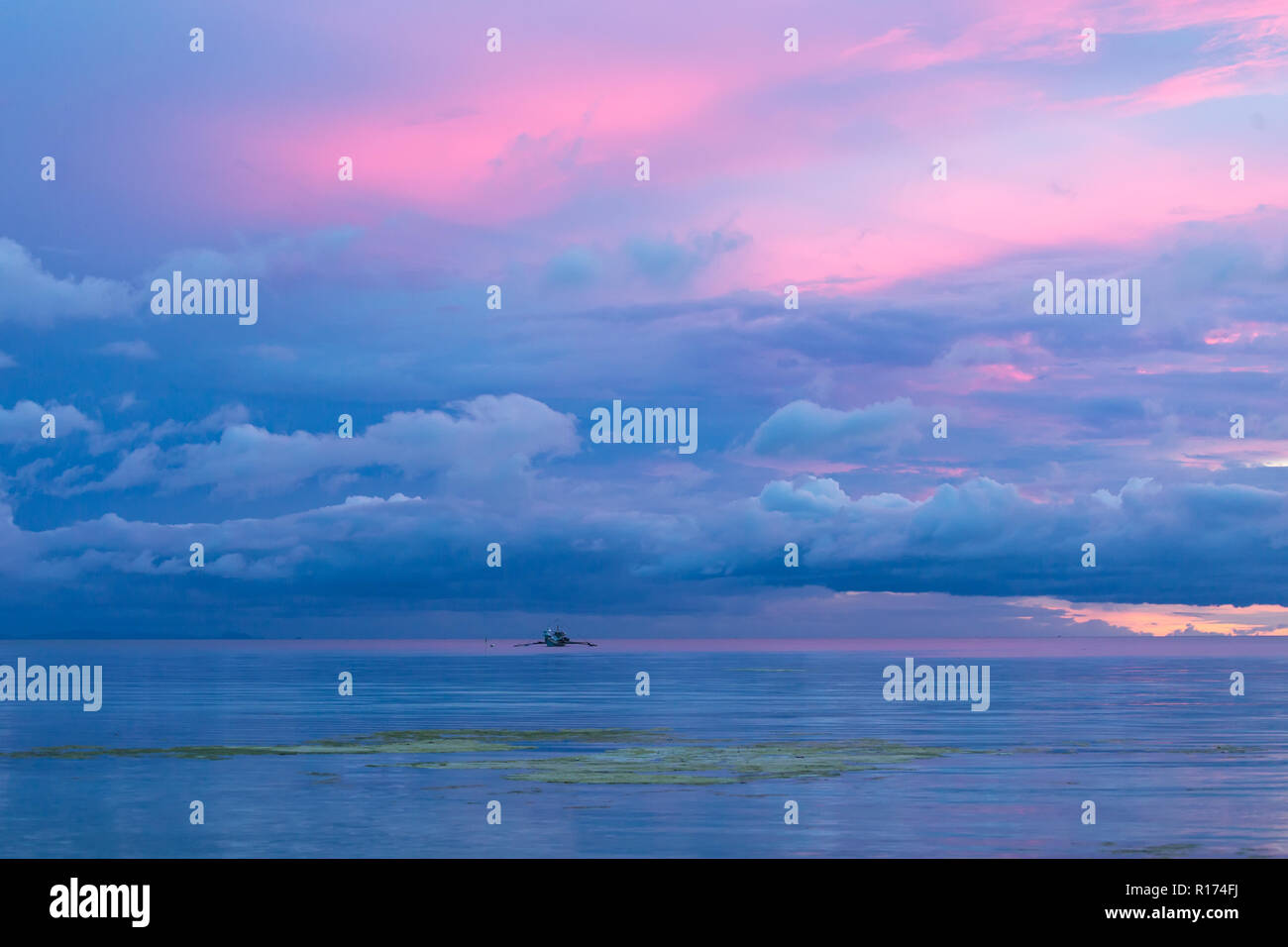 Bella Blu crepuscolo tramonto nelle Filippine con la rosa, blu e viola i colori del cielo si riflette nella calma oceano tranquillo sotto contro Foto Stock