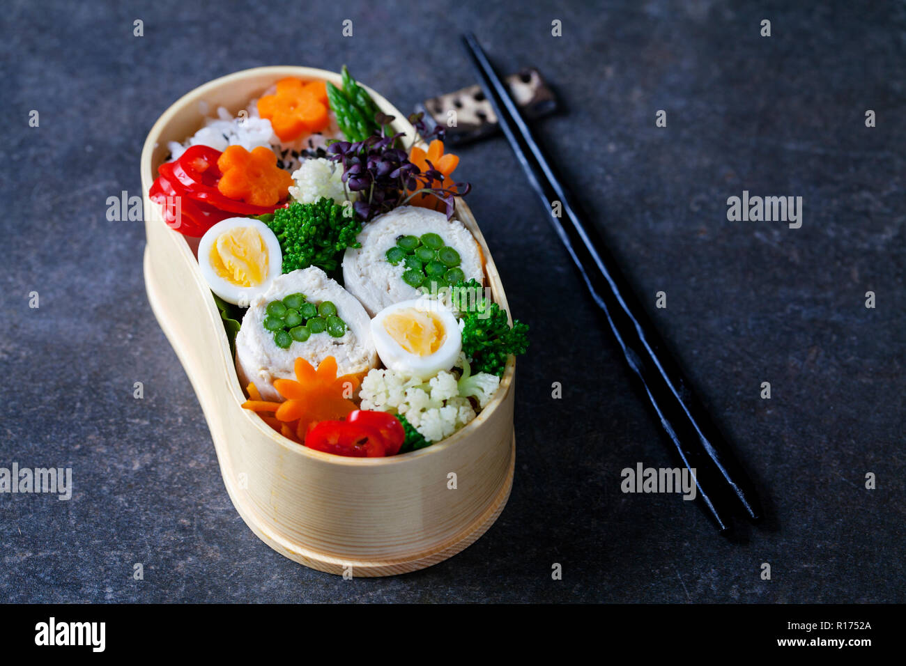 Giapponese scatola di Bento con pollo farcito con asparagi, riso, verdure e uova di quaglia Foto Stock