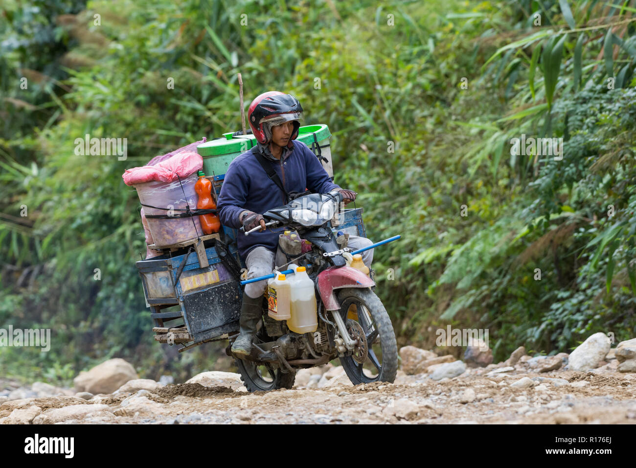 Merci di tutti i tipi vengono trasportati in moto in area rurale. Arfak montagna, Papua occidentale, in Indonesia. Foto Stock